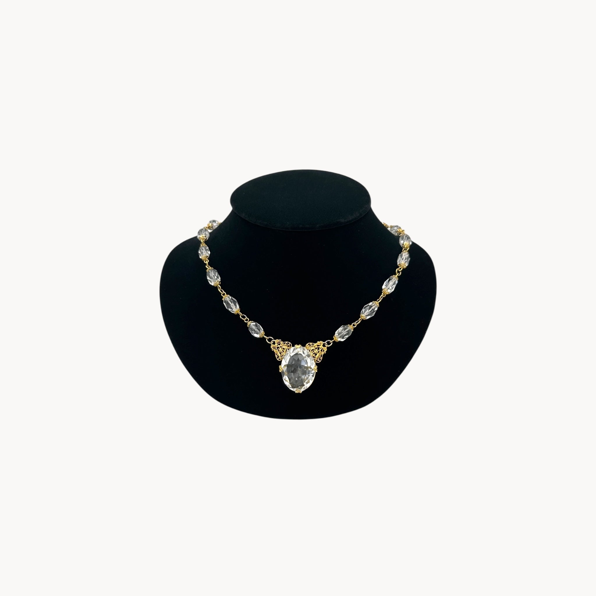 Vintage gold filigree necklace with faceted oval crystal centerpiece and linked crystal bead.