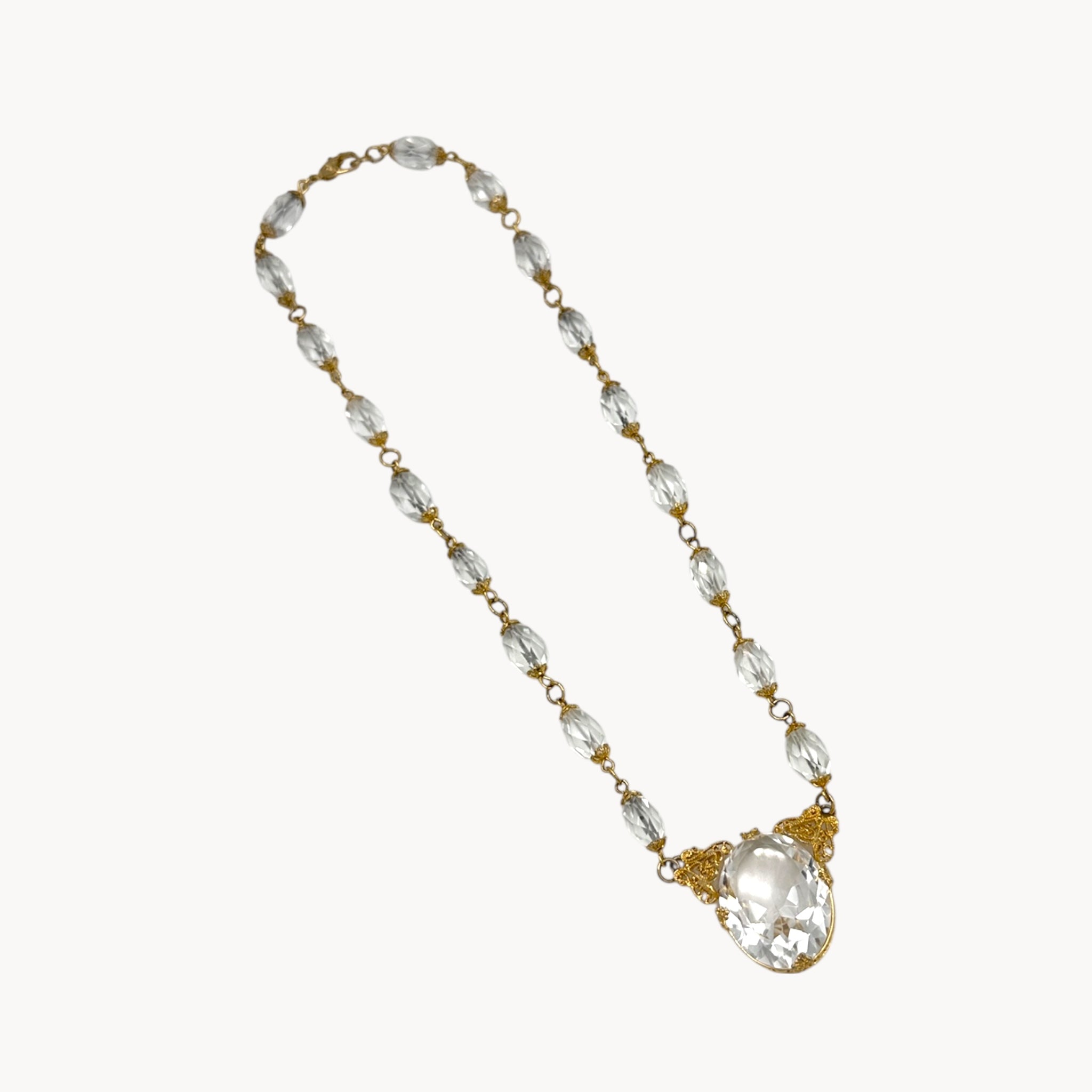 Necklace with clear beads and a large crystal pendant on a white background