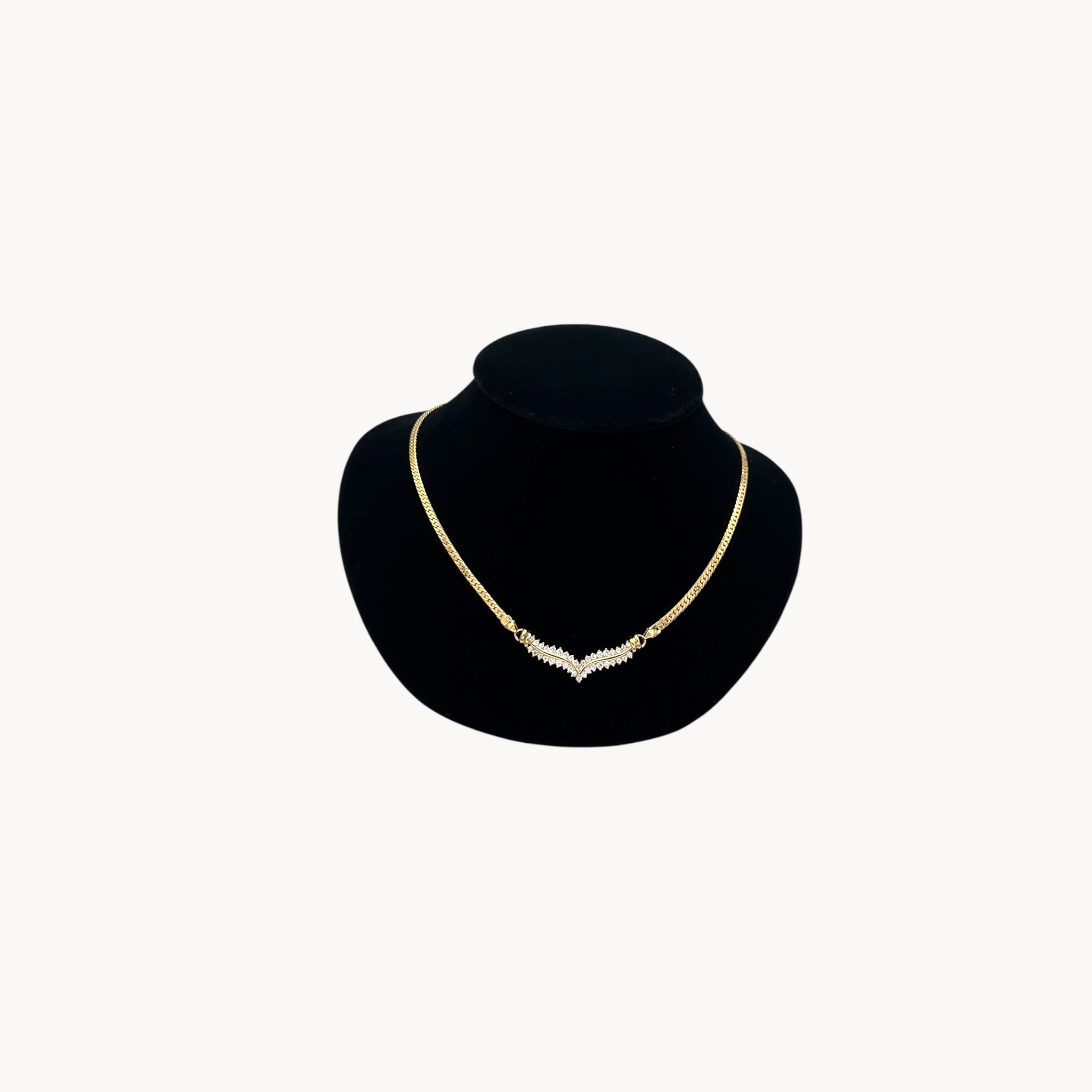 Vintage gold rhinestone chevron necklace from the 1980s–1990s on black display bust.