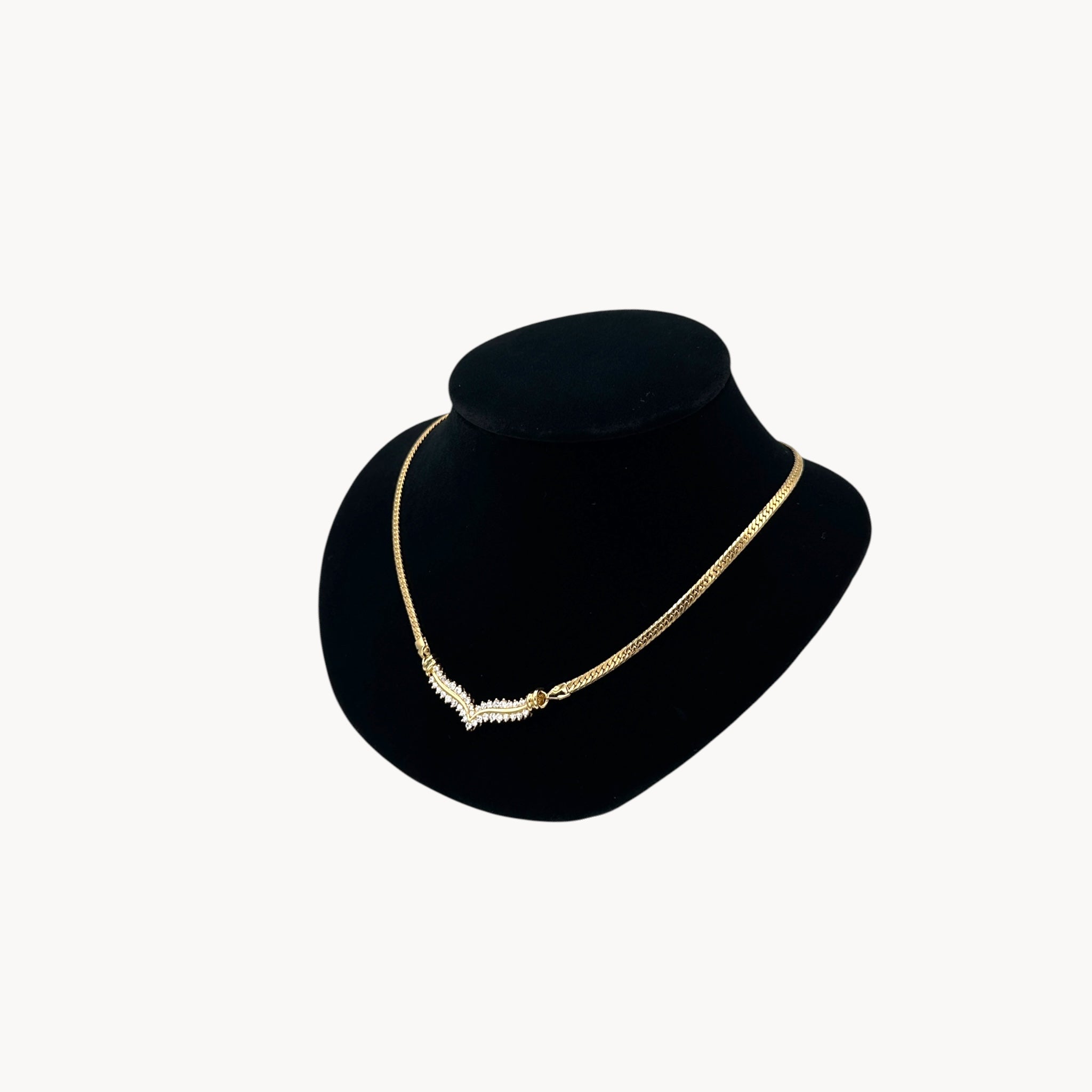 Side view of Vintage gold rhinestone chevron necklace from the 1980s–1990s on black display bust.