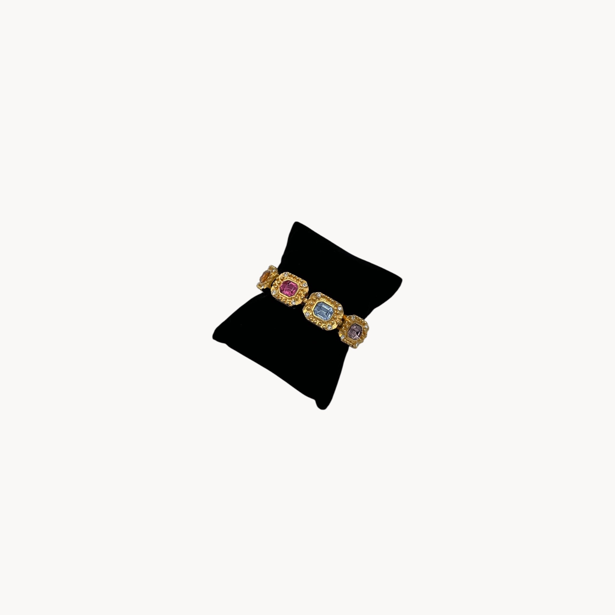 Side view Vintage Kenneth Jay Lane bracelet with multicolor emerald-cut rhinestones framed in gold-tone and pavé crystals, 1980s–1990s statement jewelry.