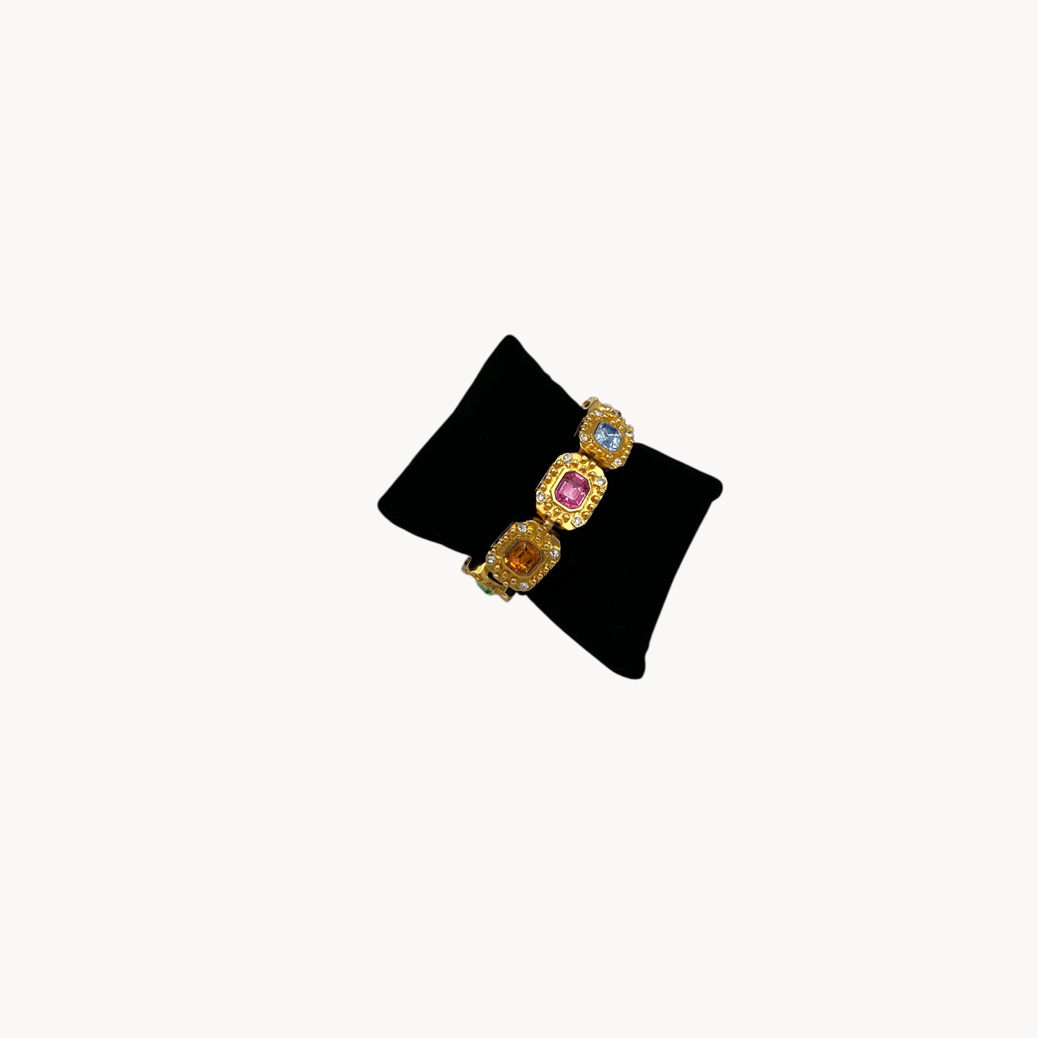 Close up side view Vintage Kenneth Jay Lane bracelet with multicolor emerald-cut rhinestones framed in gold-tone and pavé crystals, 1980s–1990s statement jewelry.