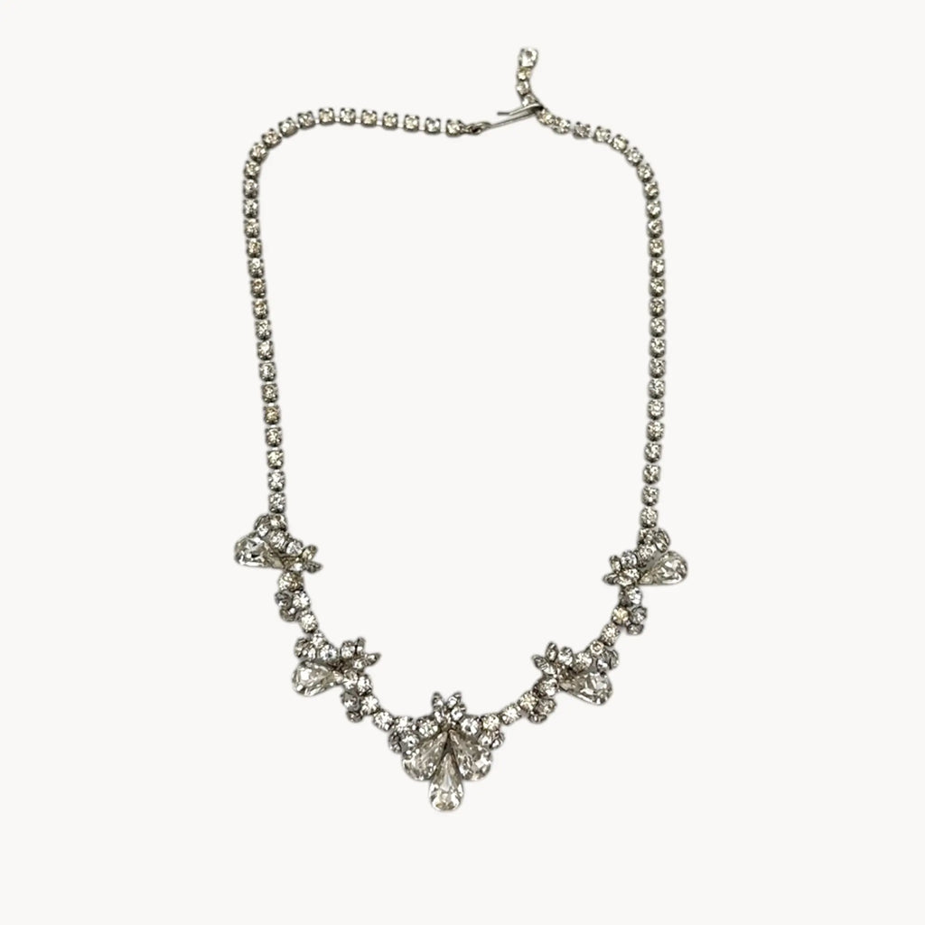 Vintage mid-century teardrop rhinestone necklace with graduated clear crystals on silver setting displayed on white background.