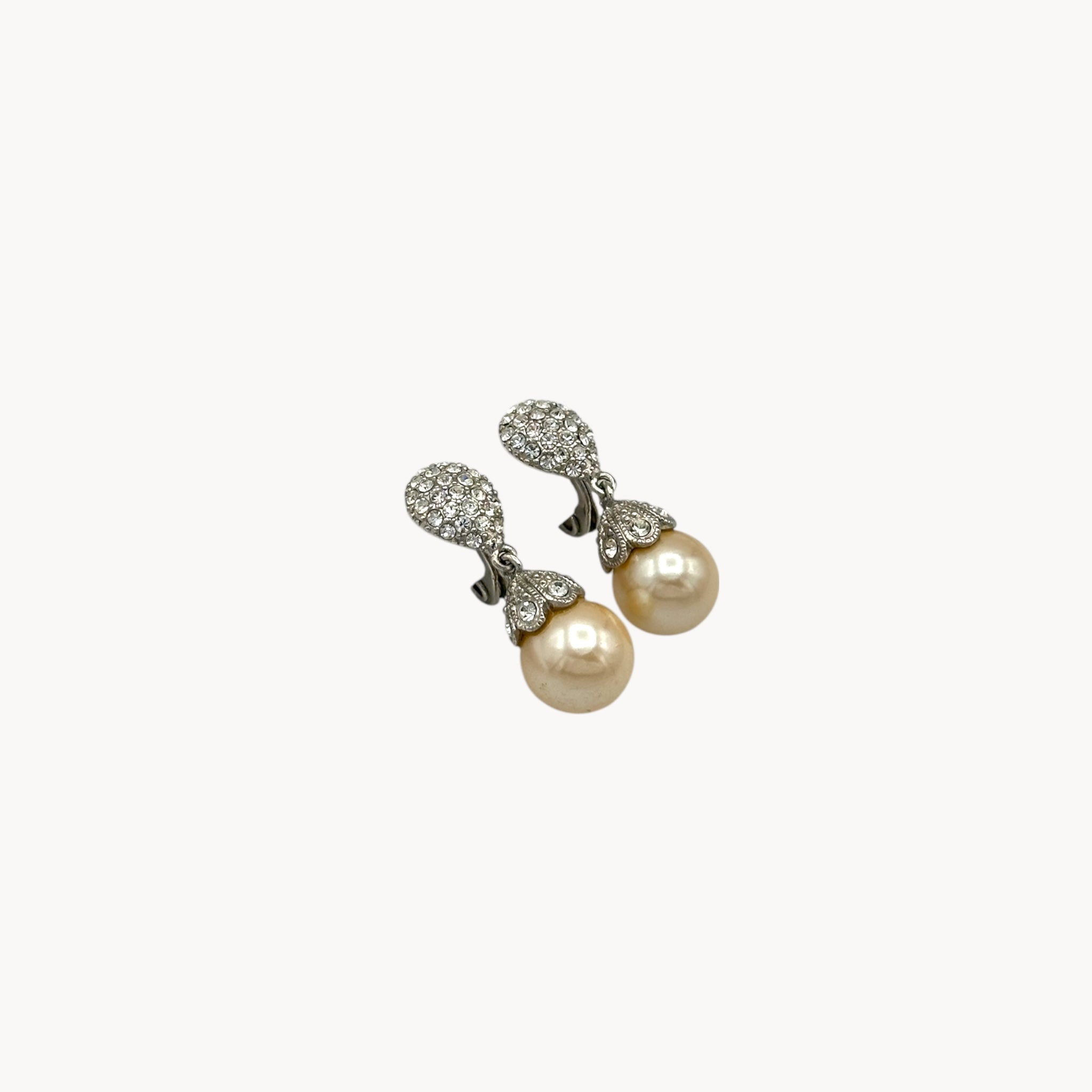 Up close view Vintage Monet clip-on earrings with faux pearls and pavé crystal accents, 1980s–1990s bridal jewelry.