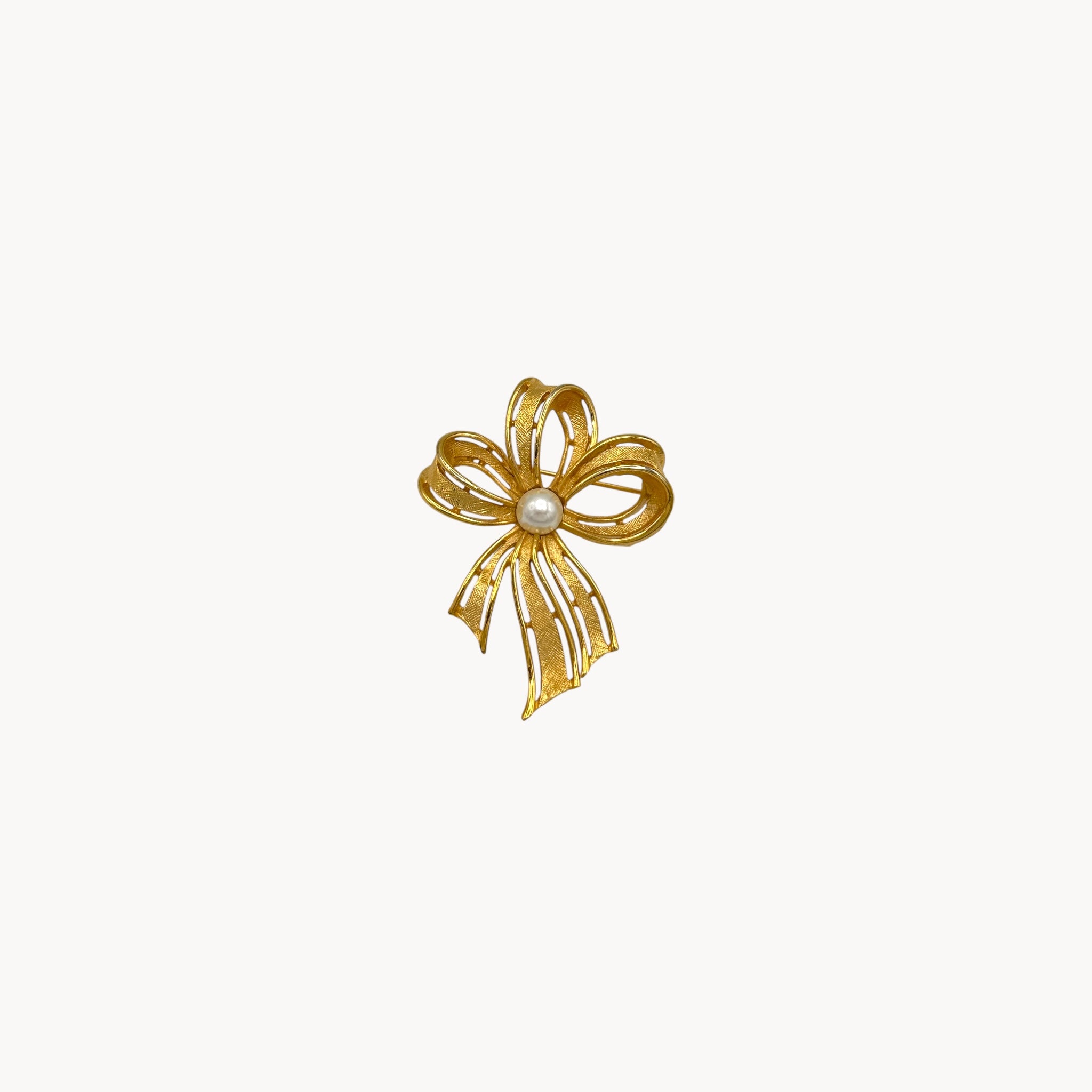 Vintage Napier gold ribbon bow brooch with pearl center.