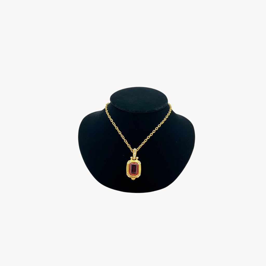 Vintage Nolan Miller long gold chain necklace with pink crystal pendant and clear crystal accents, 1980s–1990s bridal jewelry shown on black bust.