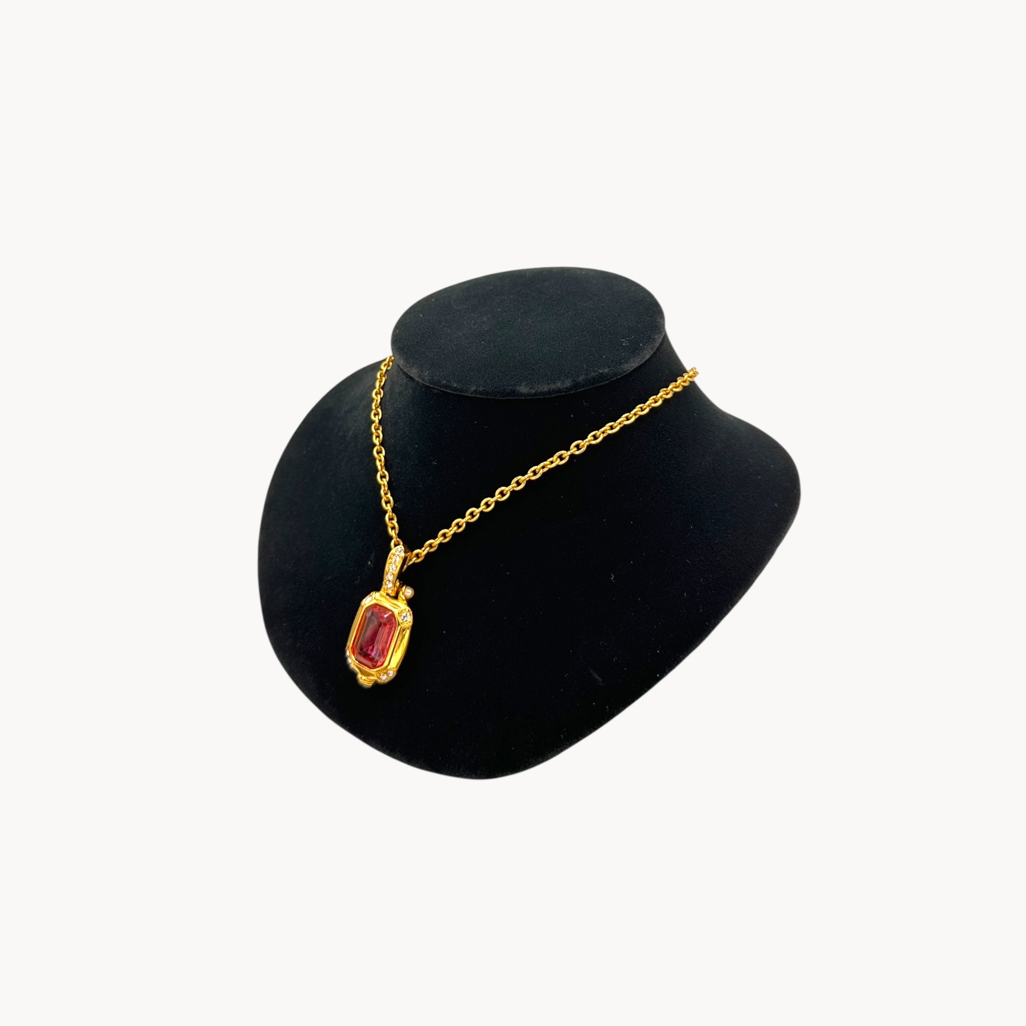 Side view of Vintage Nolan Miller long gold chain necklace with pink crystal pendant and clear crystal accents, 1980s–1990s bridal jewelry shown on black bust.