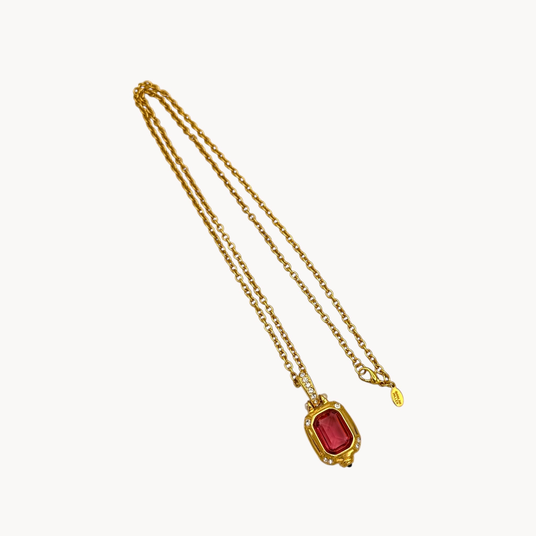 Vintage Nolan Miller long gold chain necklace with pink crystal pendant and clear crystal accents, 1980s–1990s bridal jewelry shown on white background.