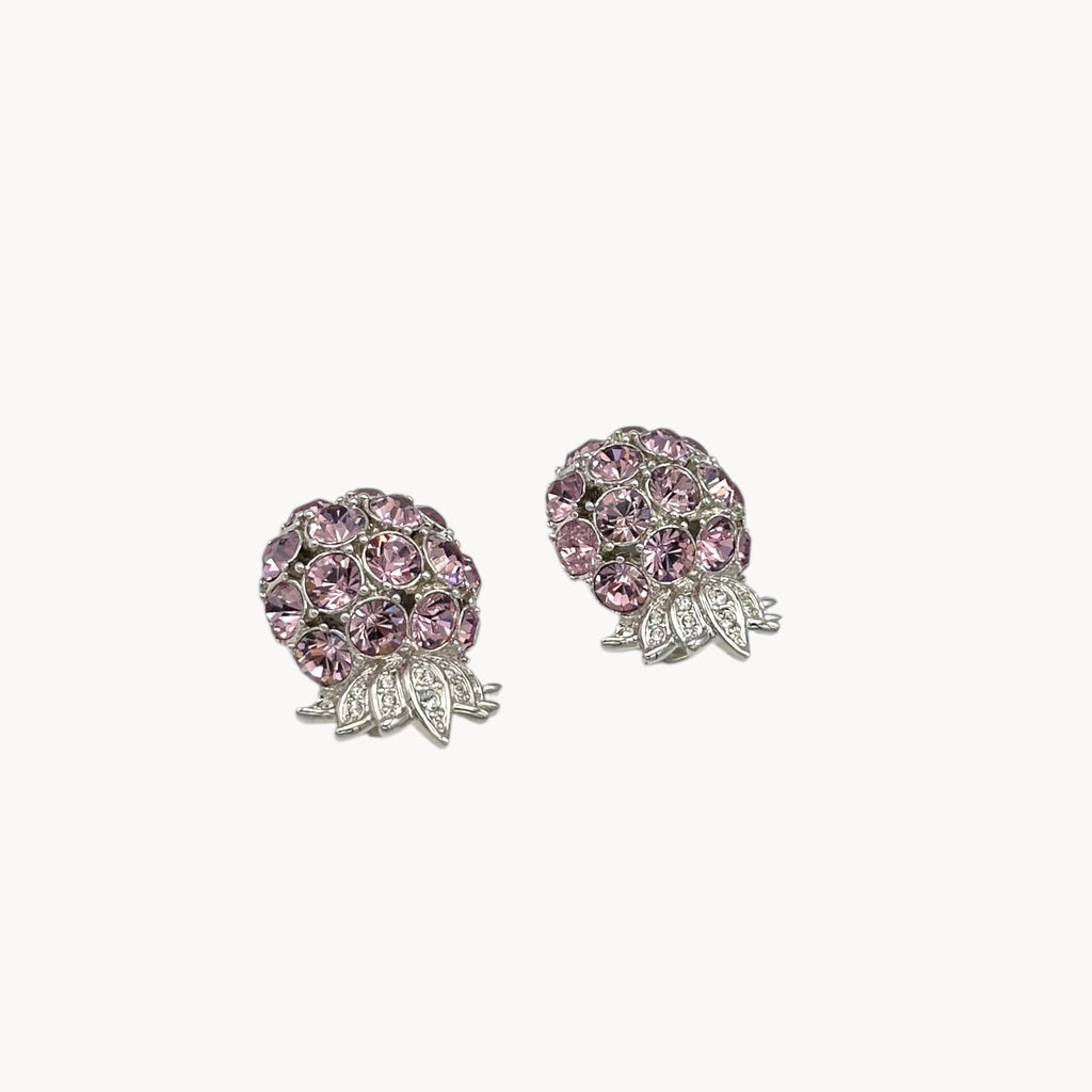 Side view of Vintage Nolan Miller pink rhinestone floral clip-on earrings with silver-tone leaves
