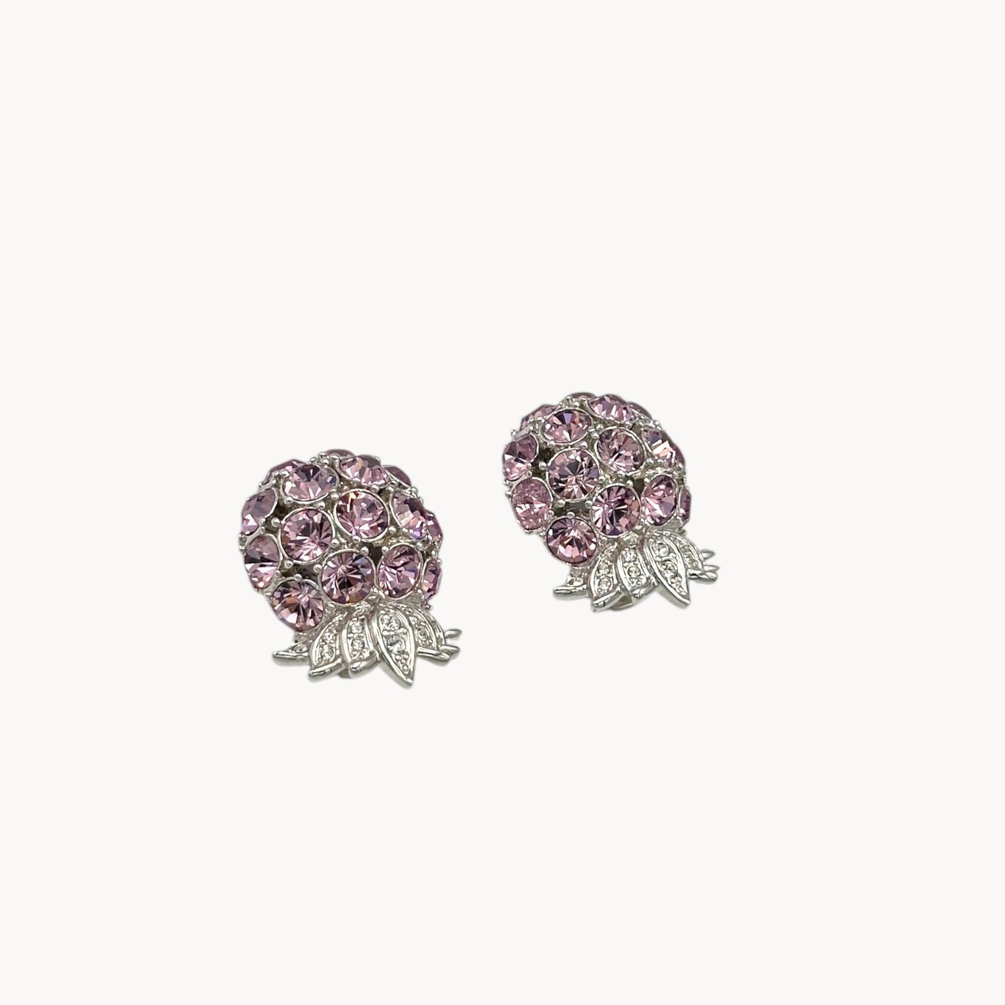 Side view of Vintage Nolan Miller pink rhinestone floral clip-on earrings with silver-tone leaves