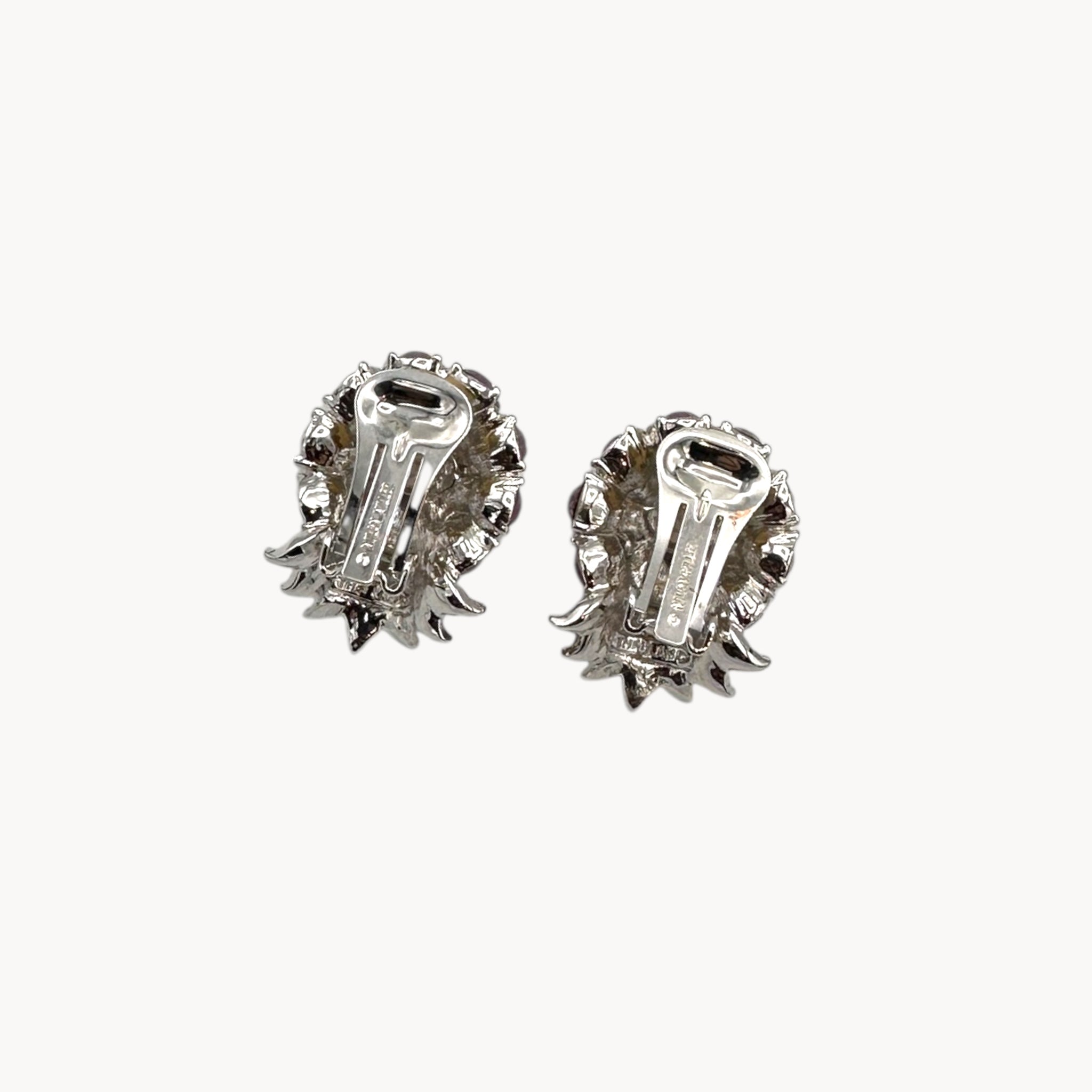 Back view of Vintage Nolan Miller rhinestone floral clip-on earrings with silver-tone leaves