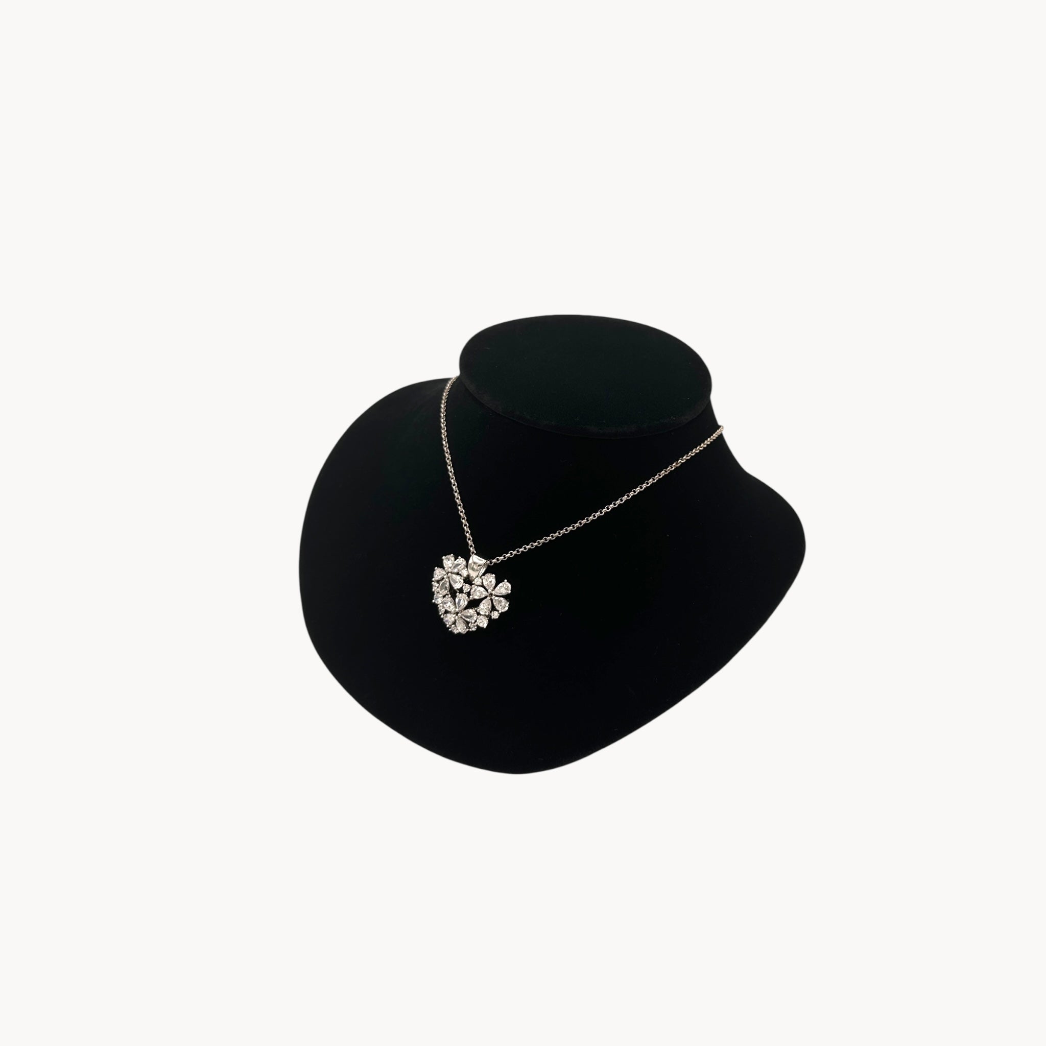 Side view of Vintage Nolan Miller rhinestone heart pendant necklace on silver chain.