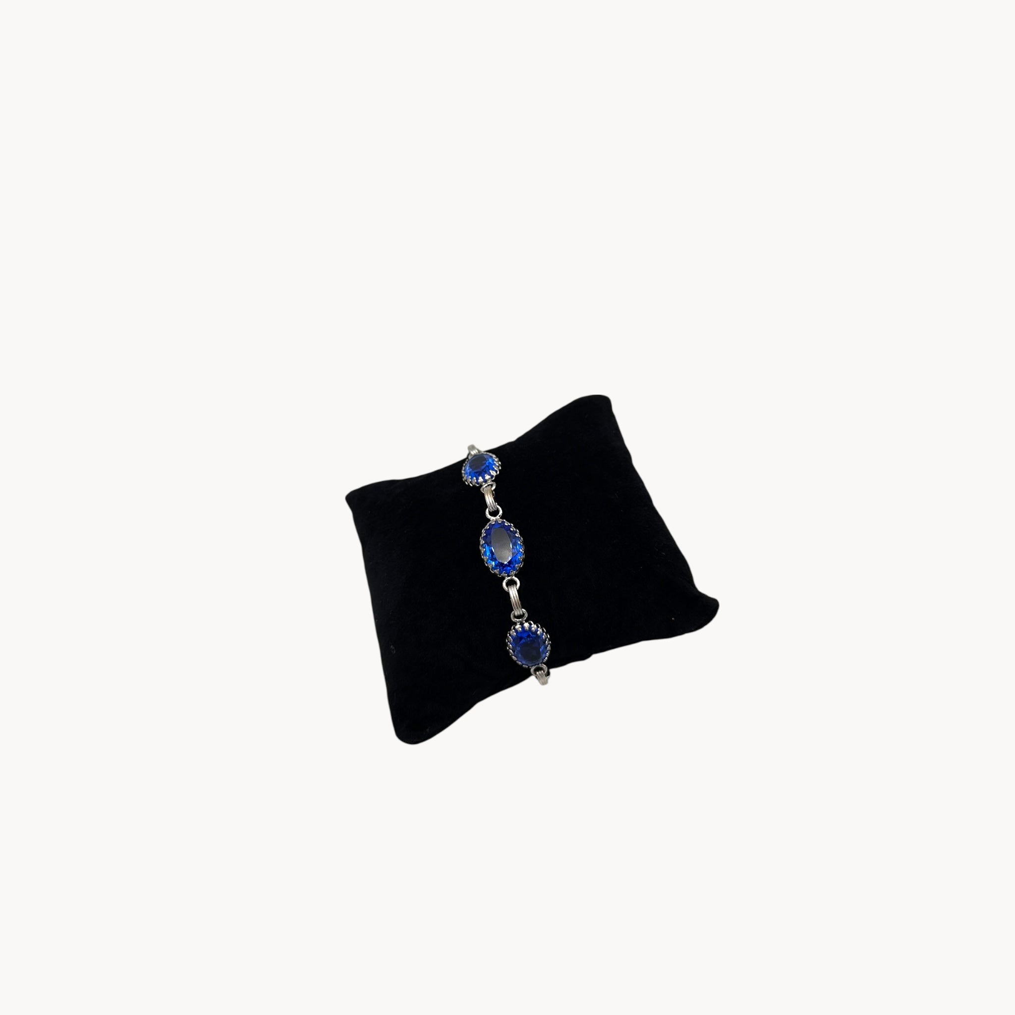 Side view of Vintage sterling silver blue glass link bracelet with oval sapphire-toned stones, mid-century bridal jewelry.