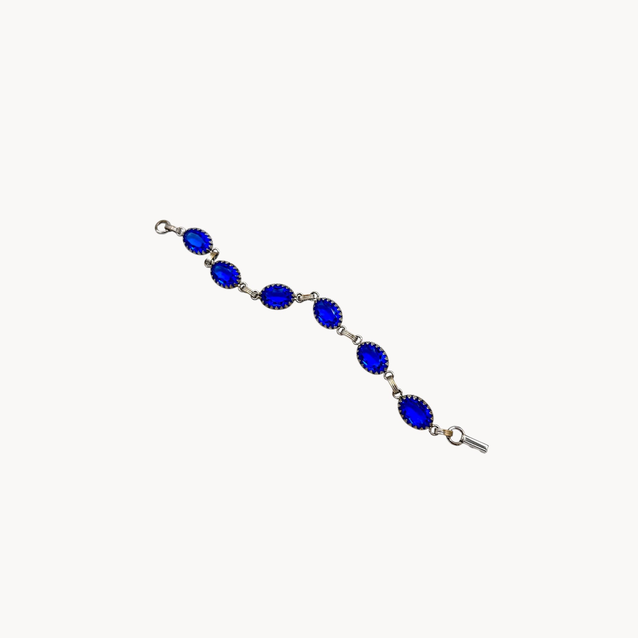 Extended view of Vintage sterling silver blue glass link bracelet with oval sapphire-toned stones, mid-century bridal jewelry.