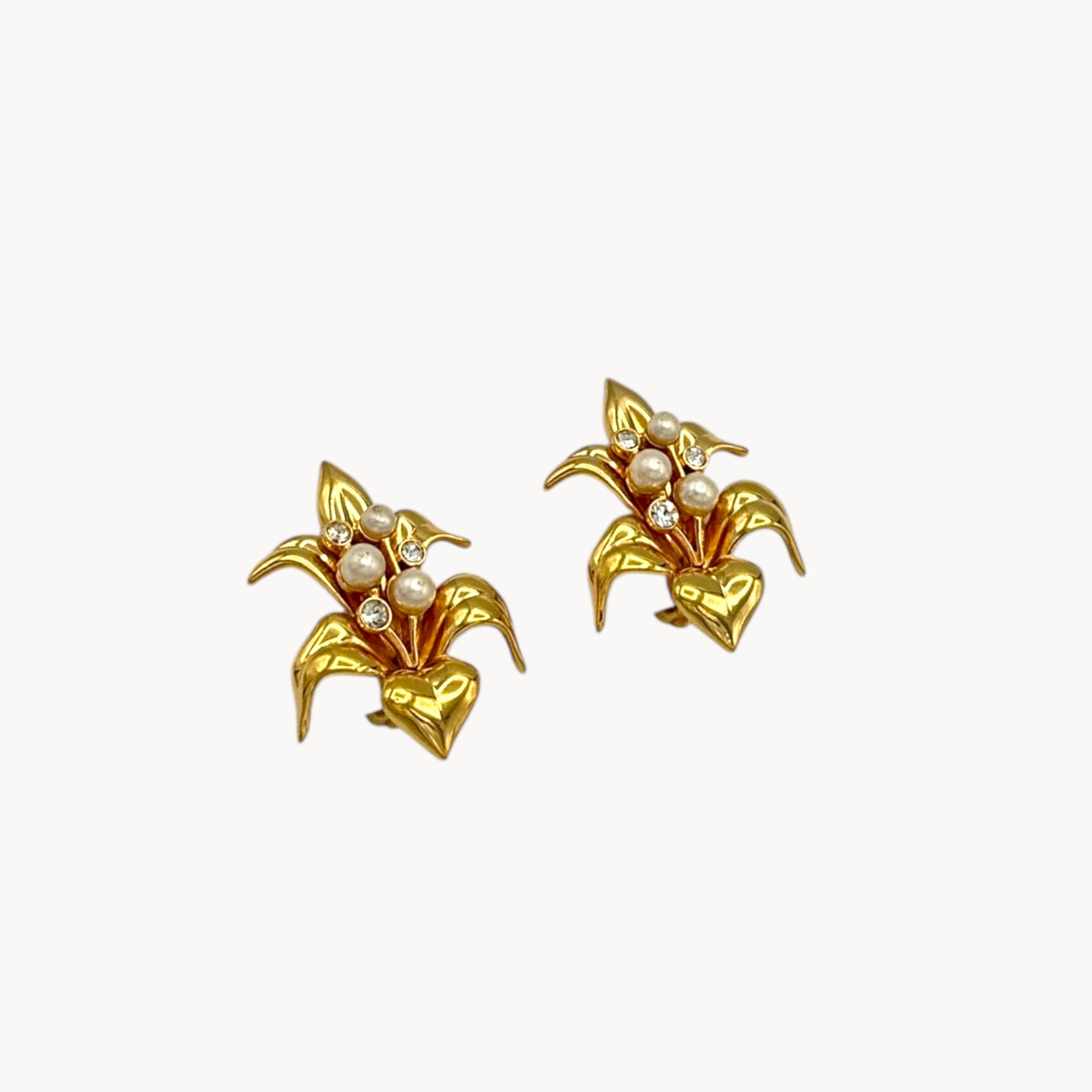 Side view of Vintage Swarovski SAL floral clip-on earrings with gold-tone petals, faux pearls, and crystal accents, 1980s bridal jewelry on white background.