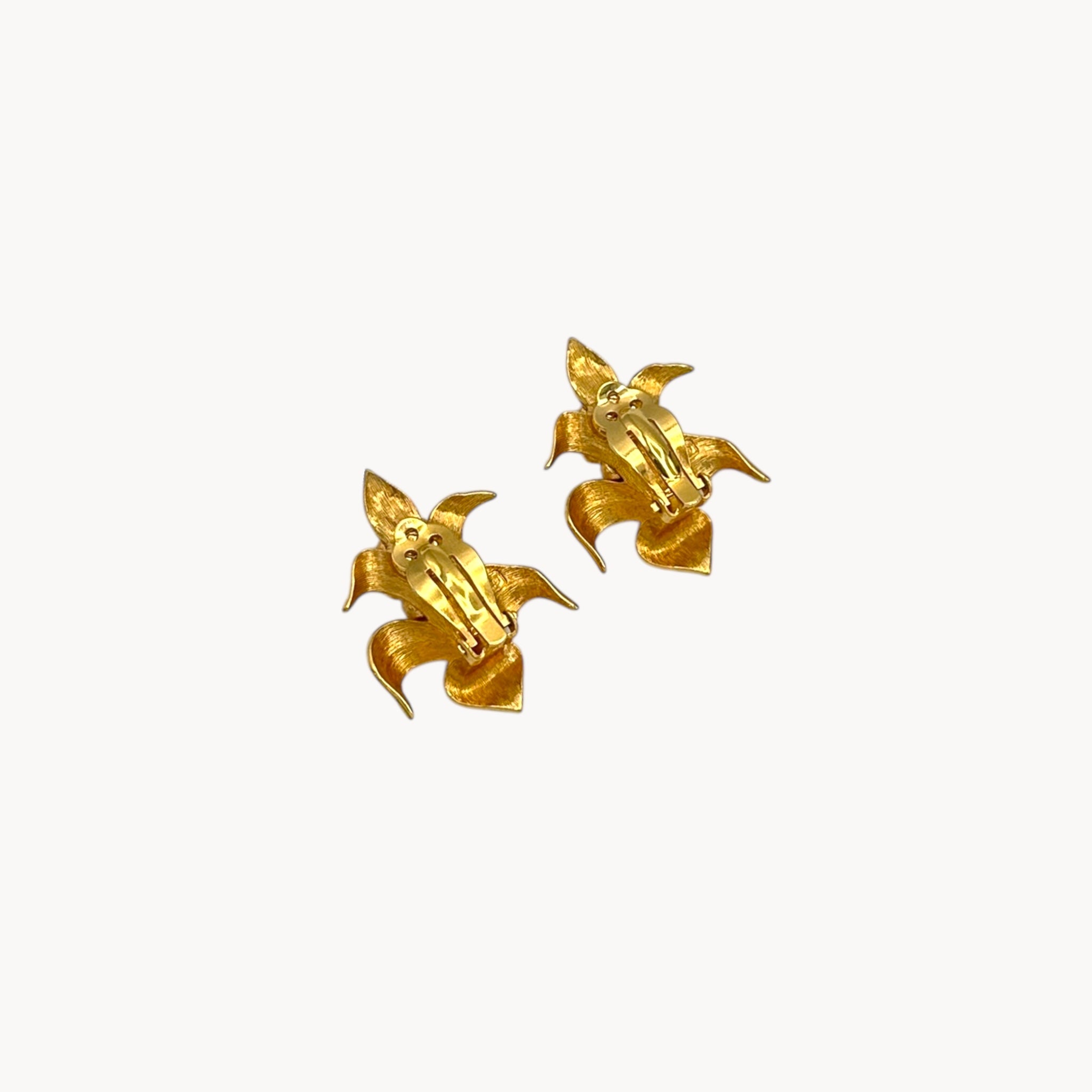 Back view of Vintage Swarovski SAL floral clip-on earrings with gold-tone petals, faux pearls, and crystal accents, 1980s bridal jewelry on white background.