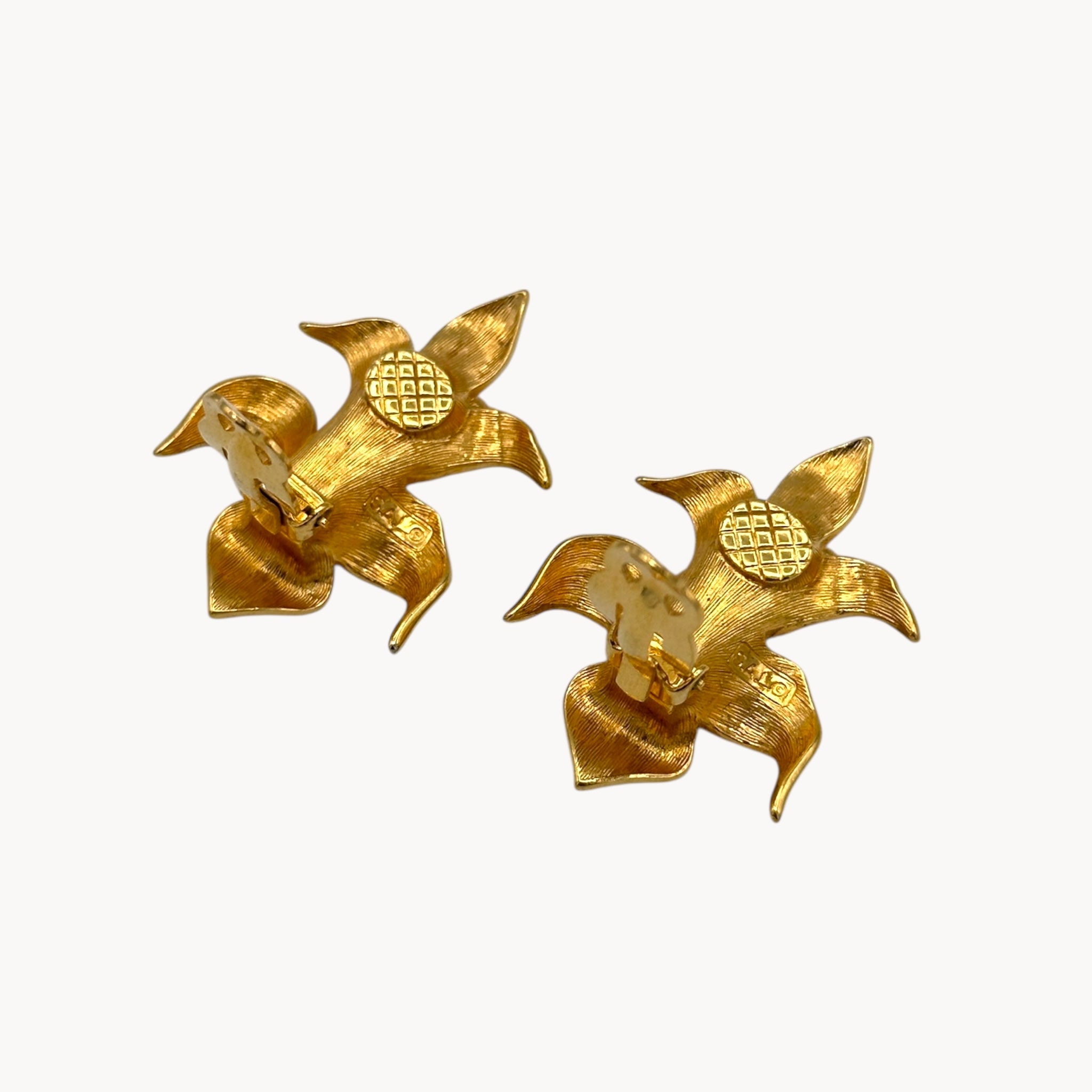 Back view with clips up of Vintage Swarovski SAL floral clip-on earrings with gold-tone petals, faux pearls, and crystal accents, 1980s bridal jewelry on white background.