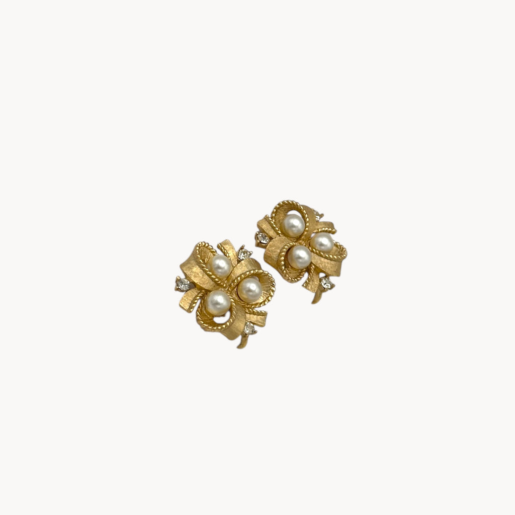 side view Vintage Trifari clip-on earrings with gold bow design, faux pearls, and crystal accents, 1960s bridal jewelry.