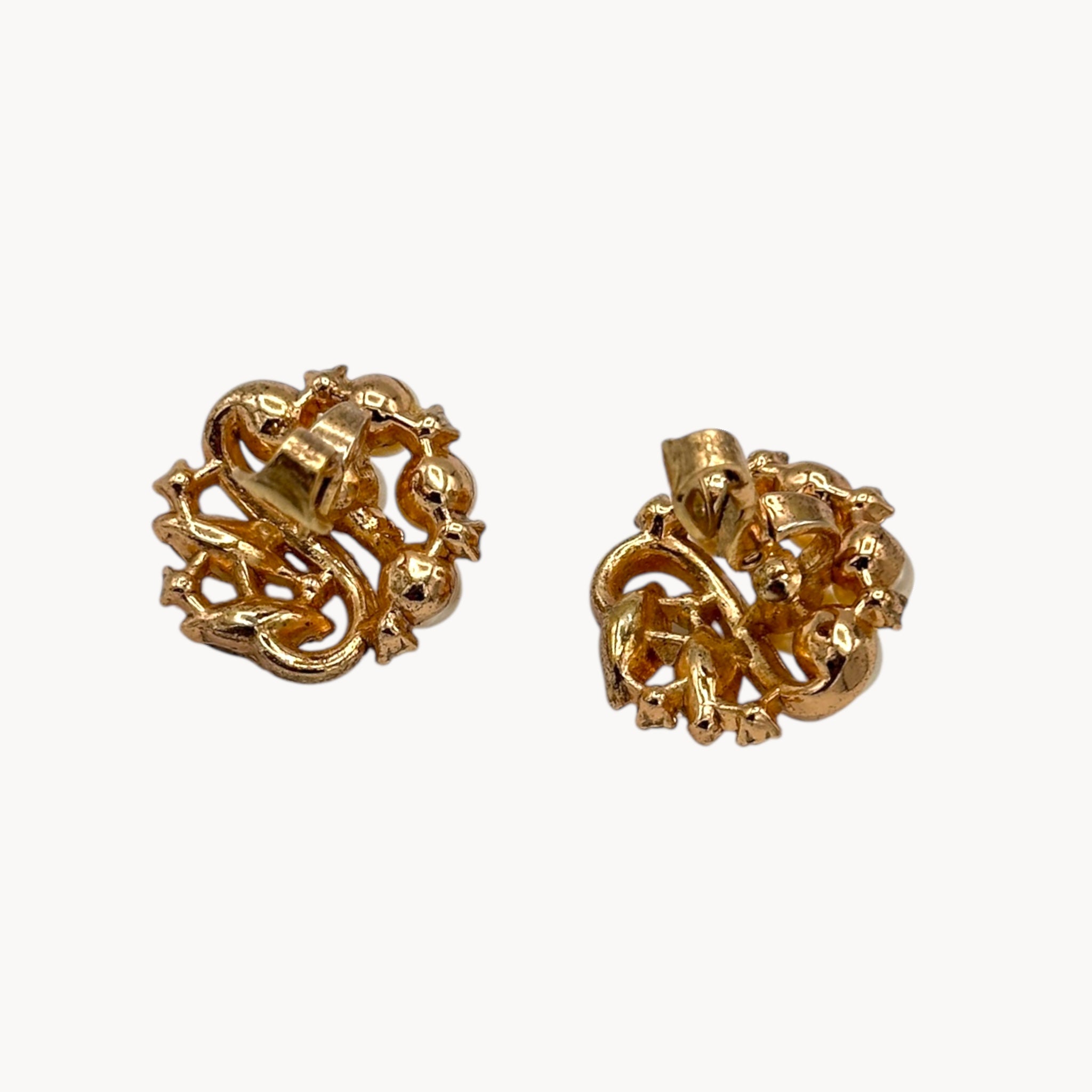 Back view of earrings of Brooch of the Vintage Trifari brooch with faux pearls, rhinestones, and gold-tone design shown on white background.