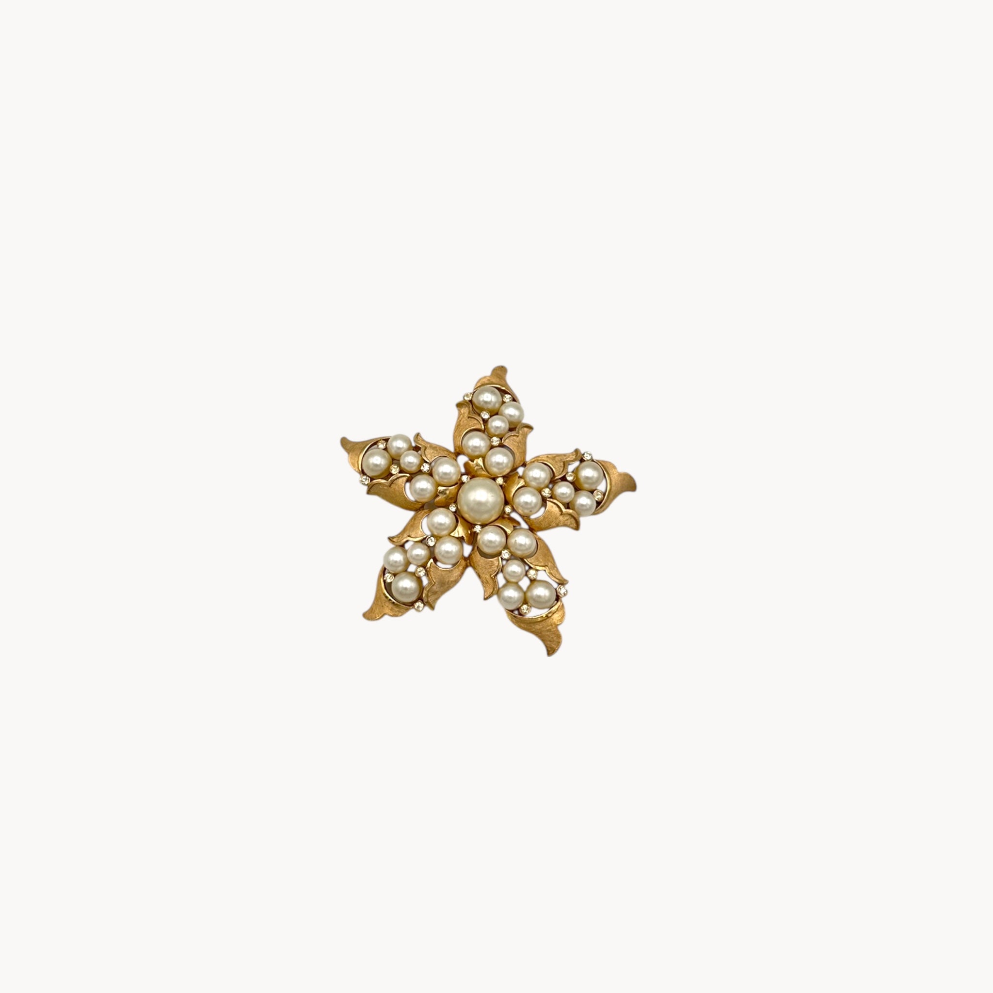 Vintage Trifari floral starfish brooch with faux pearls and rhinestones in gold-tone metal.