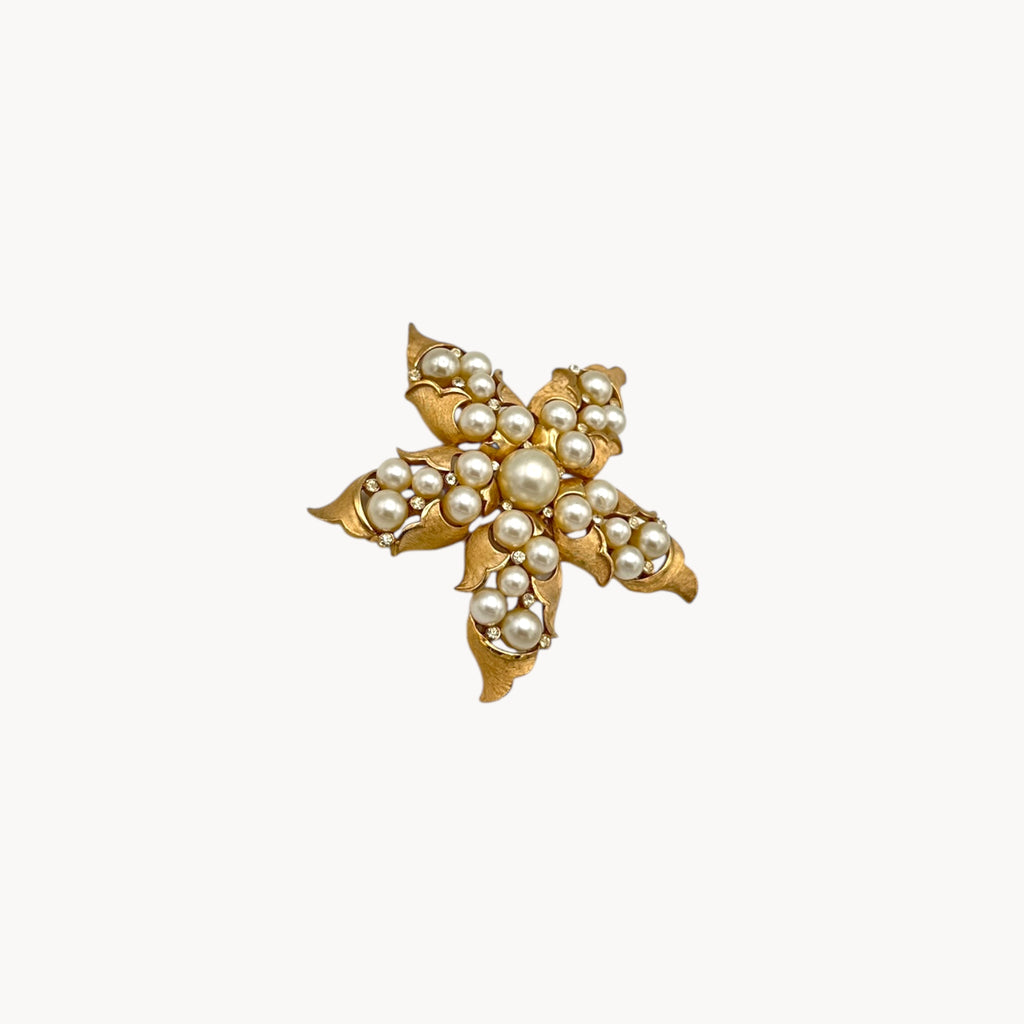 Side view of Vintage Trifari floral starfish brooch with faux pearls and rhinestones in gold-tone metal.