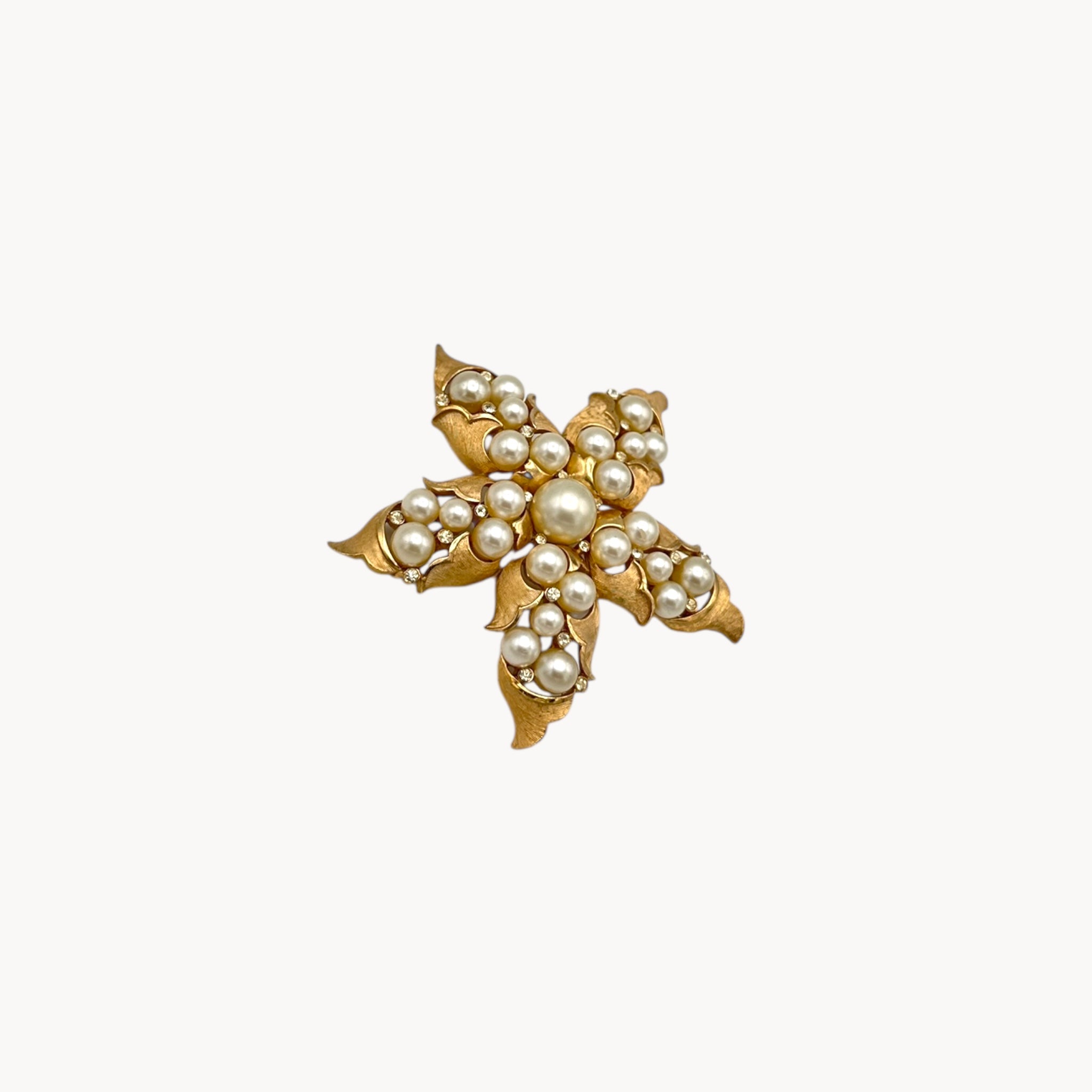 Side view of Vintage Trifari floral starfish brooch with faux pearls and rhinestones in gold-tone metal.