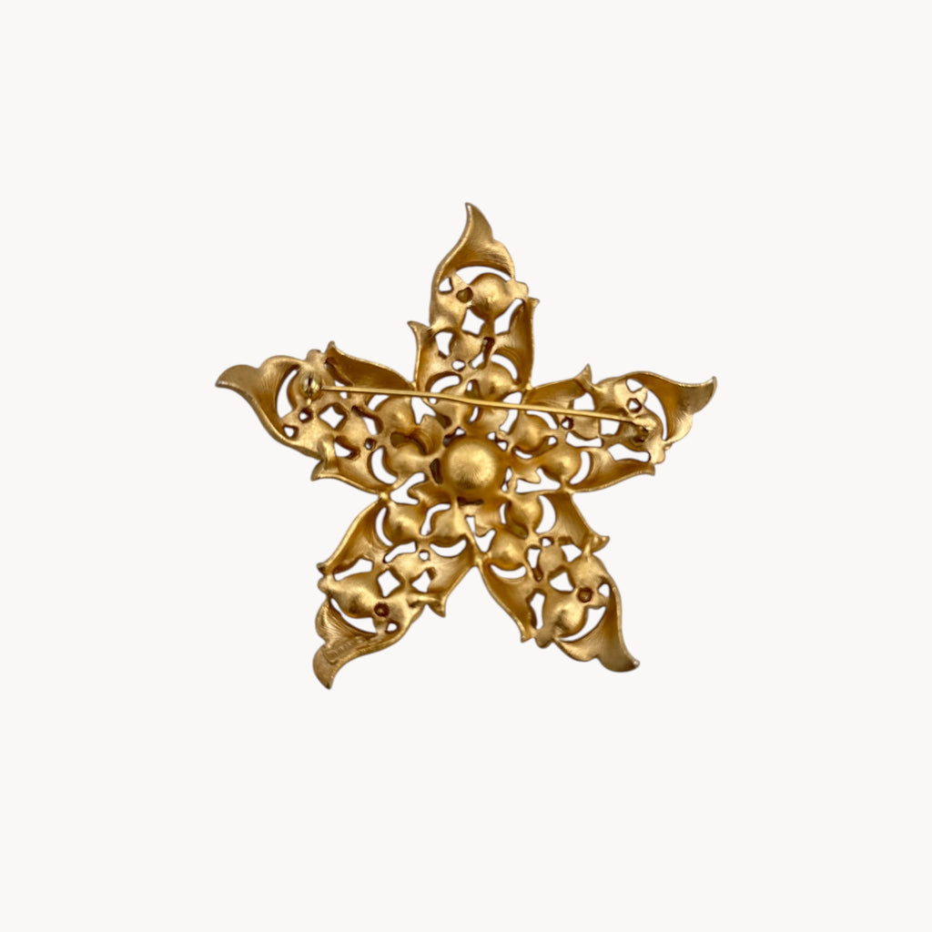 Back view of Vintage Trifari floral starfish brooch with faux pearls and rhinestones in gold-tone metal.