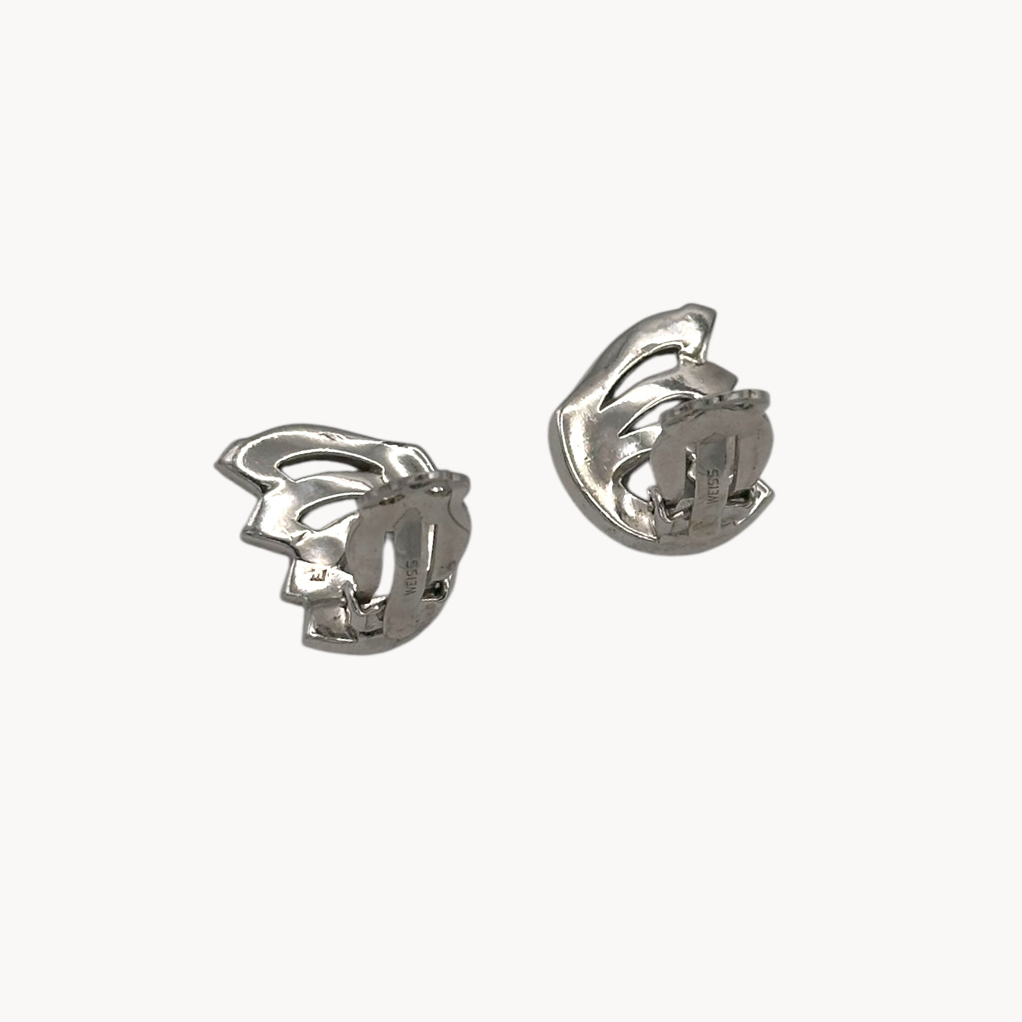 Back view with clips up of Weiss vintage clip-on rhinestone earrings with baguette and round stones in silver-tone setting.