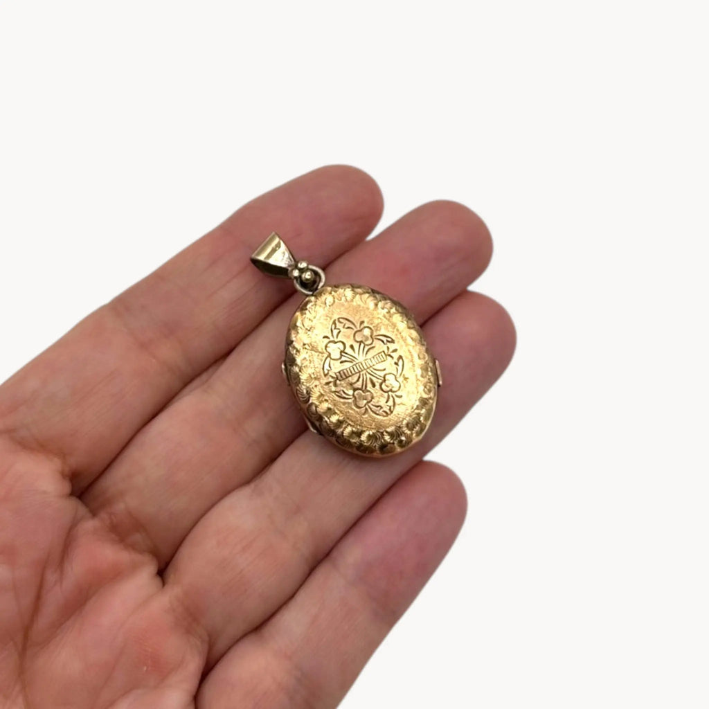 Scale view Antique gold-filled etched floral locket with ornate border, Victorian keepsake pendant.