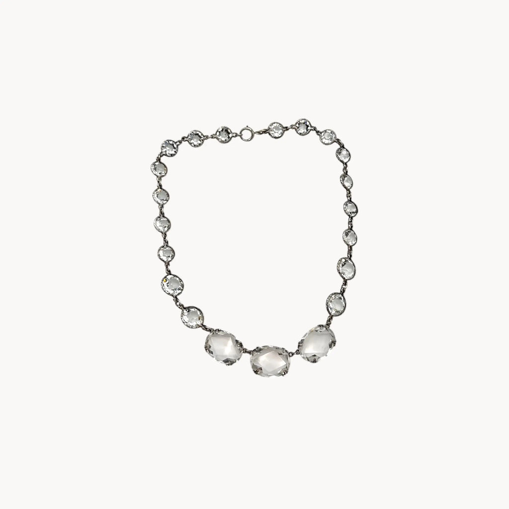 Vintage Art Deco crystal necklace with round and oval-cut crystals, stones on white background.