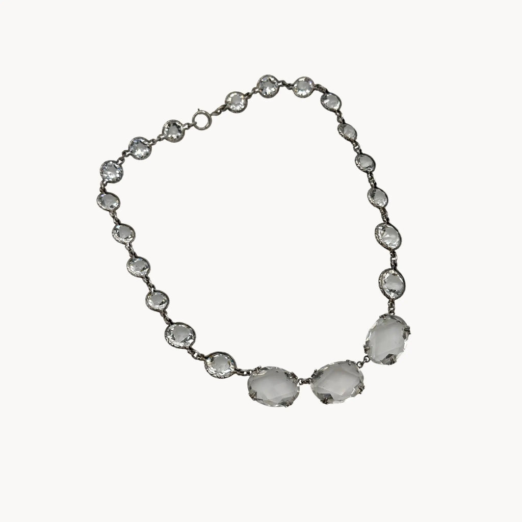 Side view of Vintage Art Deco crystal necklace with round and oval-cut crystals, stones on white background.