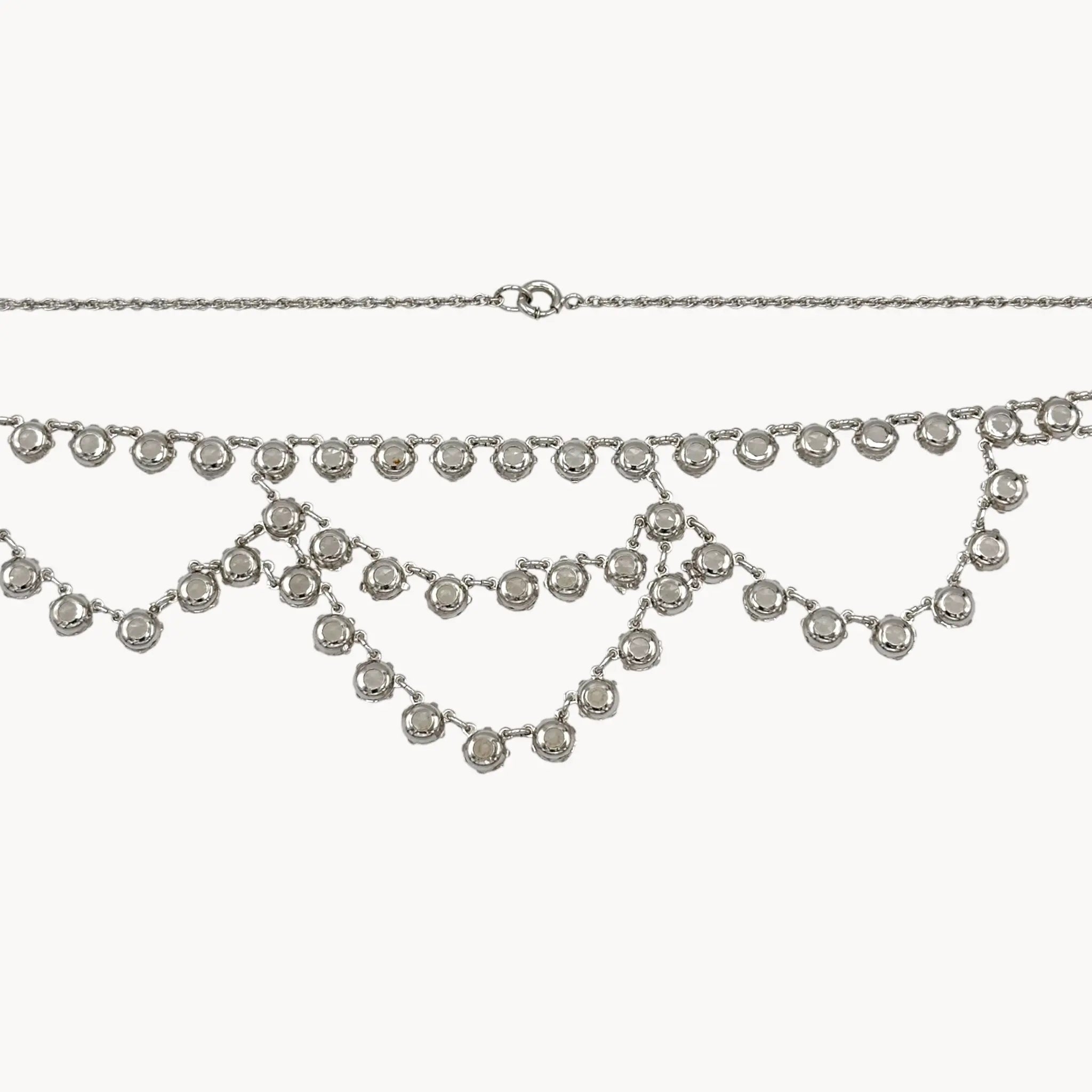 Back view of Art Deco style 12K gold-filled rhodium plated crystal draped necklace on white background.