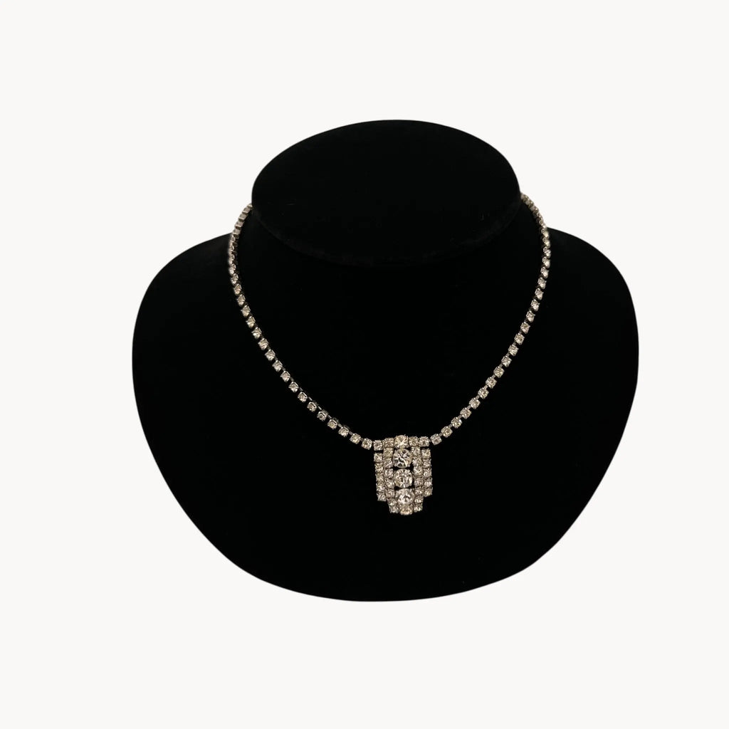 Close up view of 1950s Art Deco style rhinestone necklace with geometric pendant drop, vintage mid-century bridal jewelry