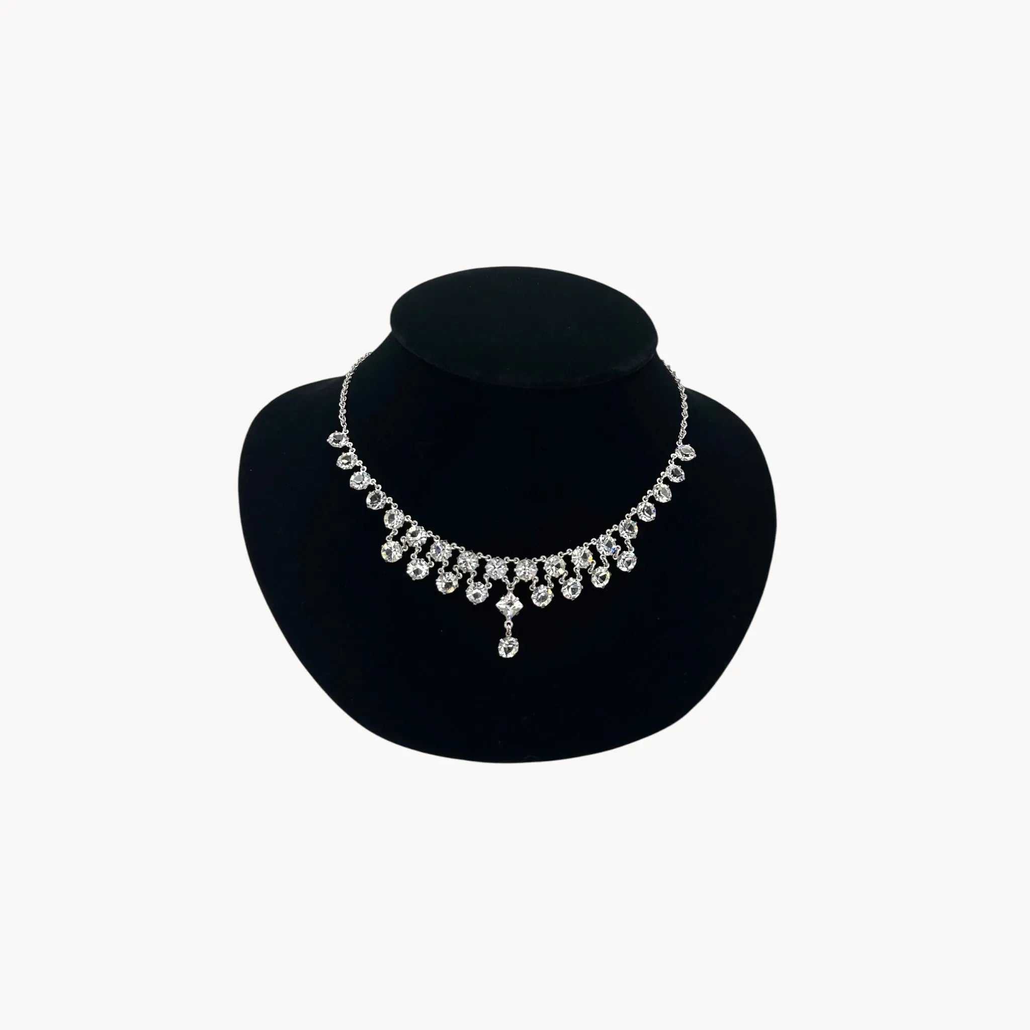 Art Deco style rhodium plated crystal fringe necklace on black bust.