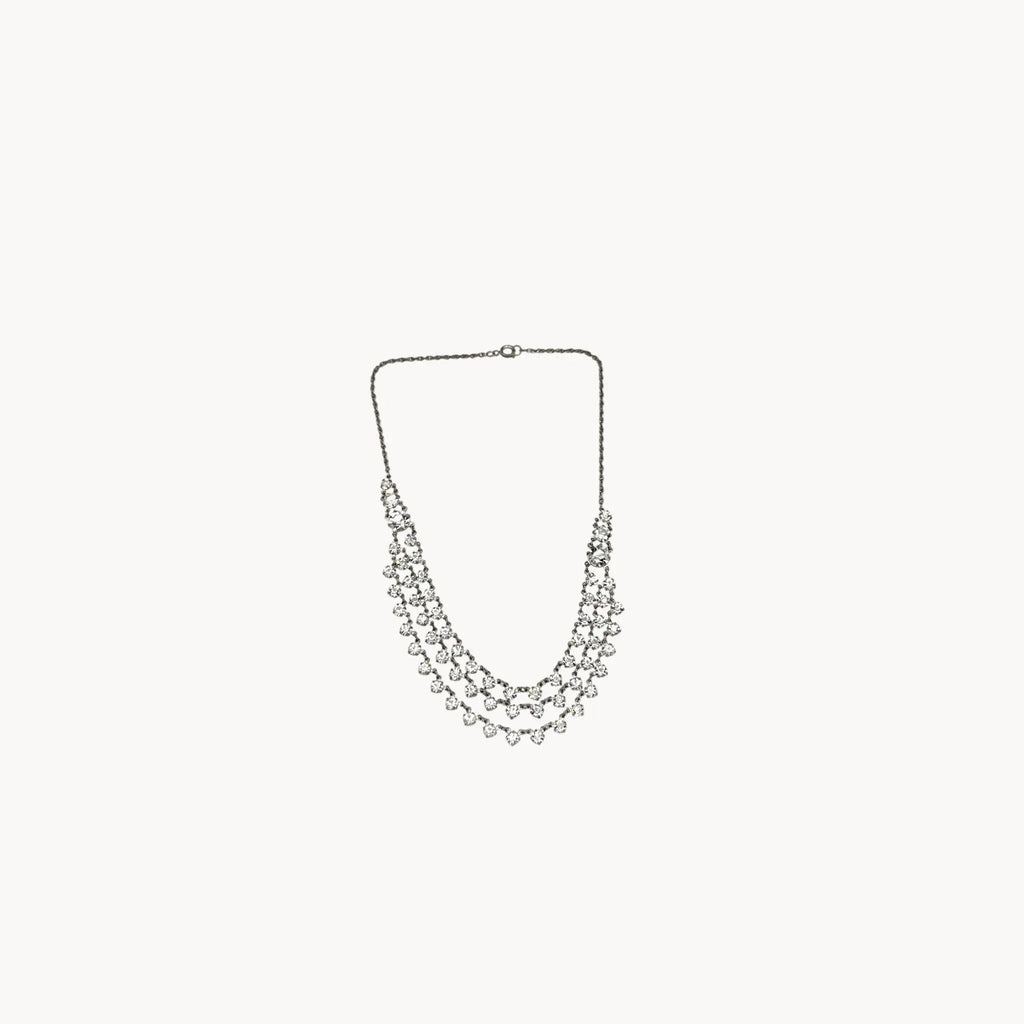 Art Deco style rhodium plated three-row crystal draped necklace on white background.