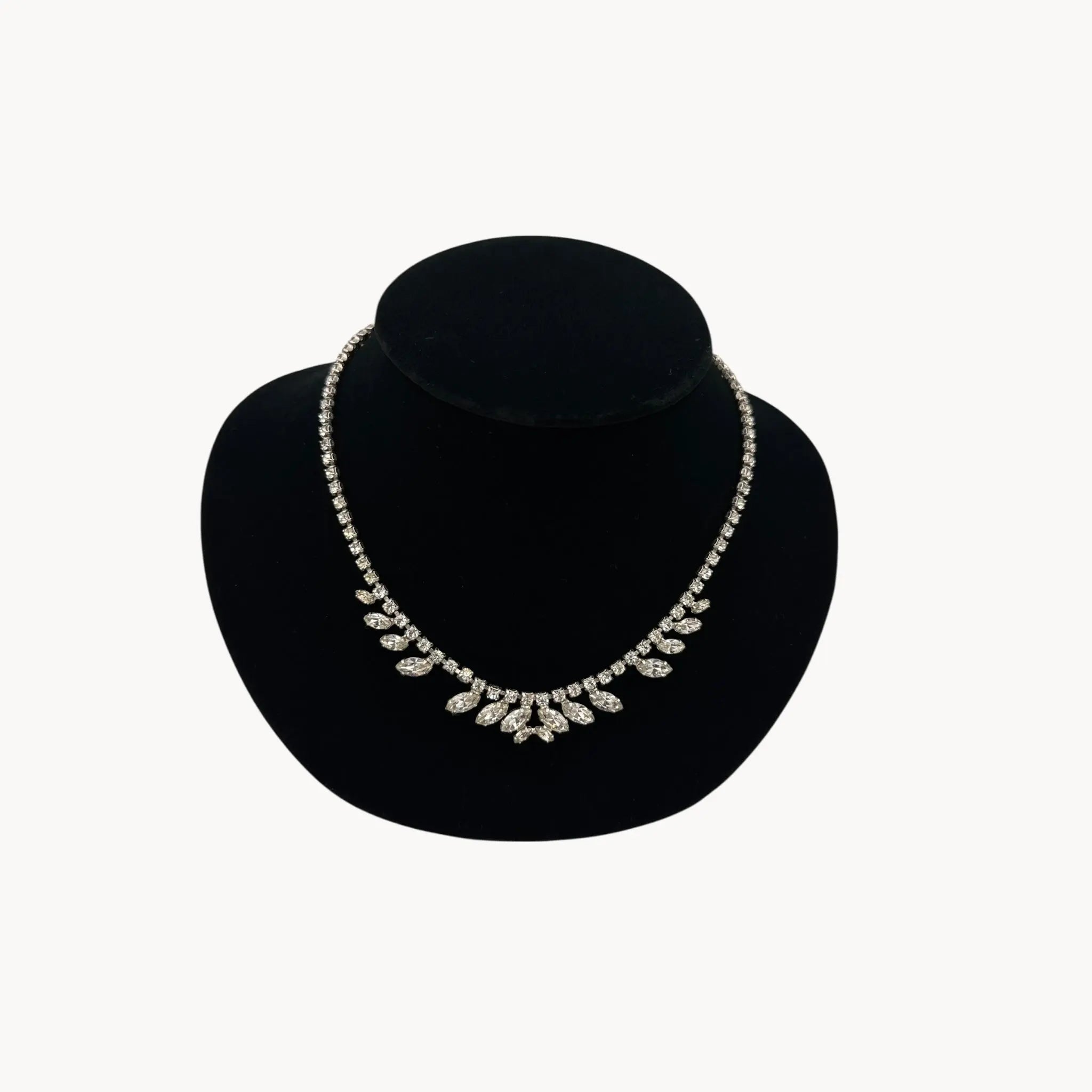 Close up view of 1950s B. David rhinestone necklace with round and marquise stones in garland design, vintage bridal jewelry.