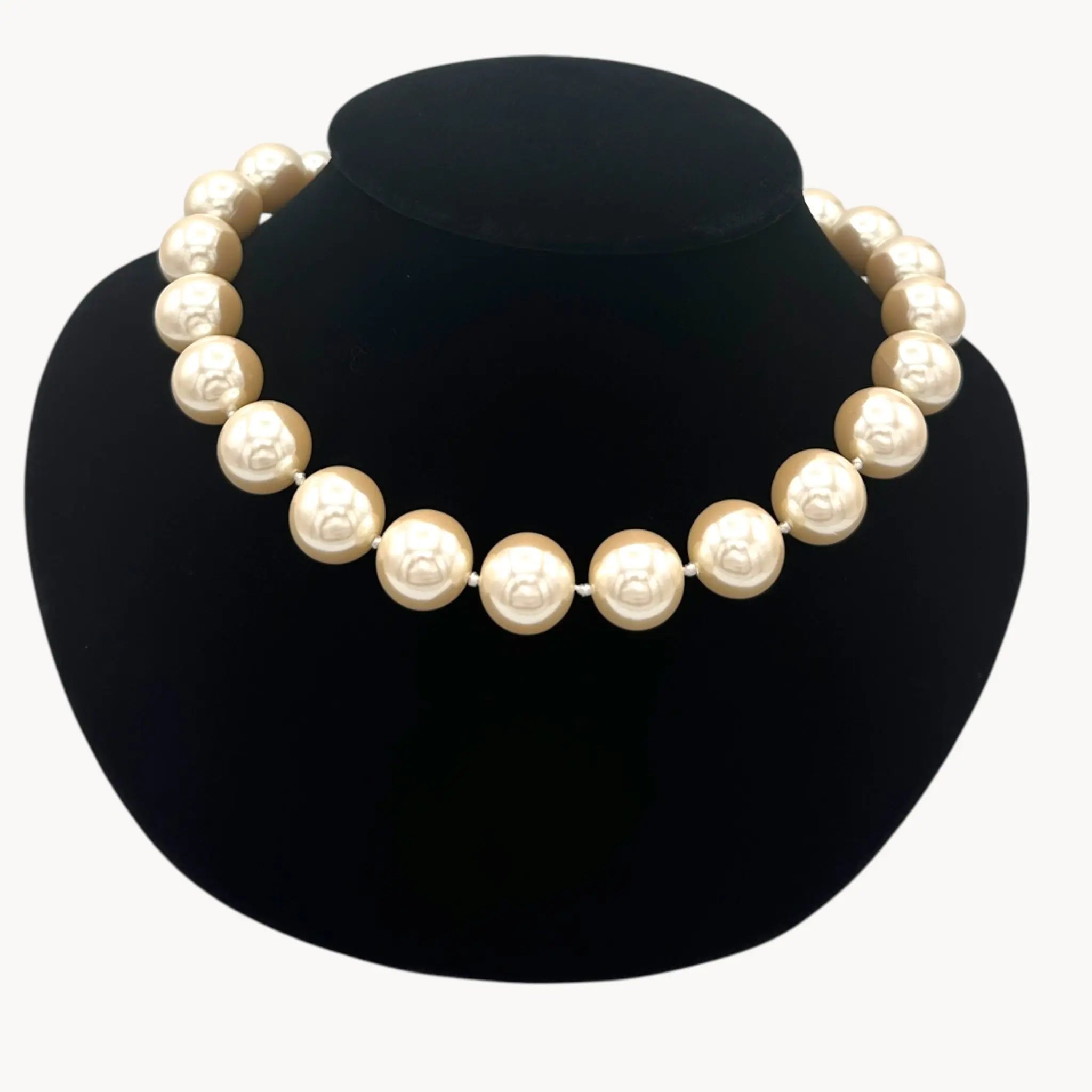 Close up view of Carolee statement faux pearl strand necklace adjustable on black bust.