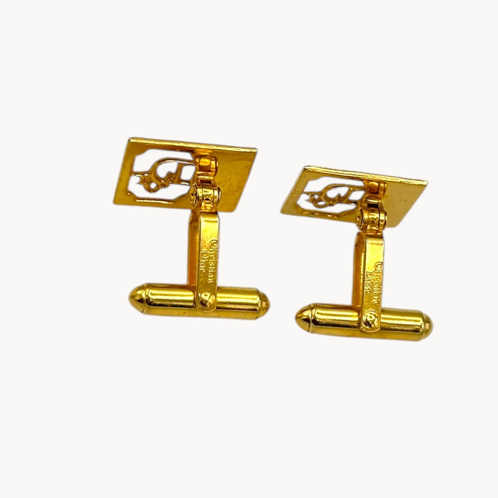 Designer stamp of Vintage Christian Dior gold-plated square cufflinks with logo cutout design displayed on white background.