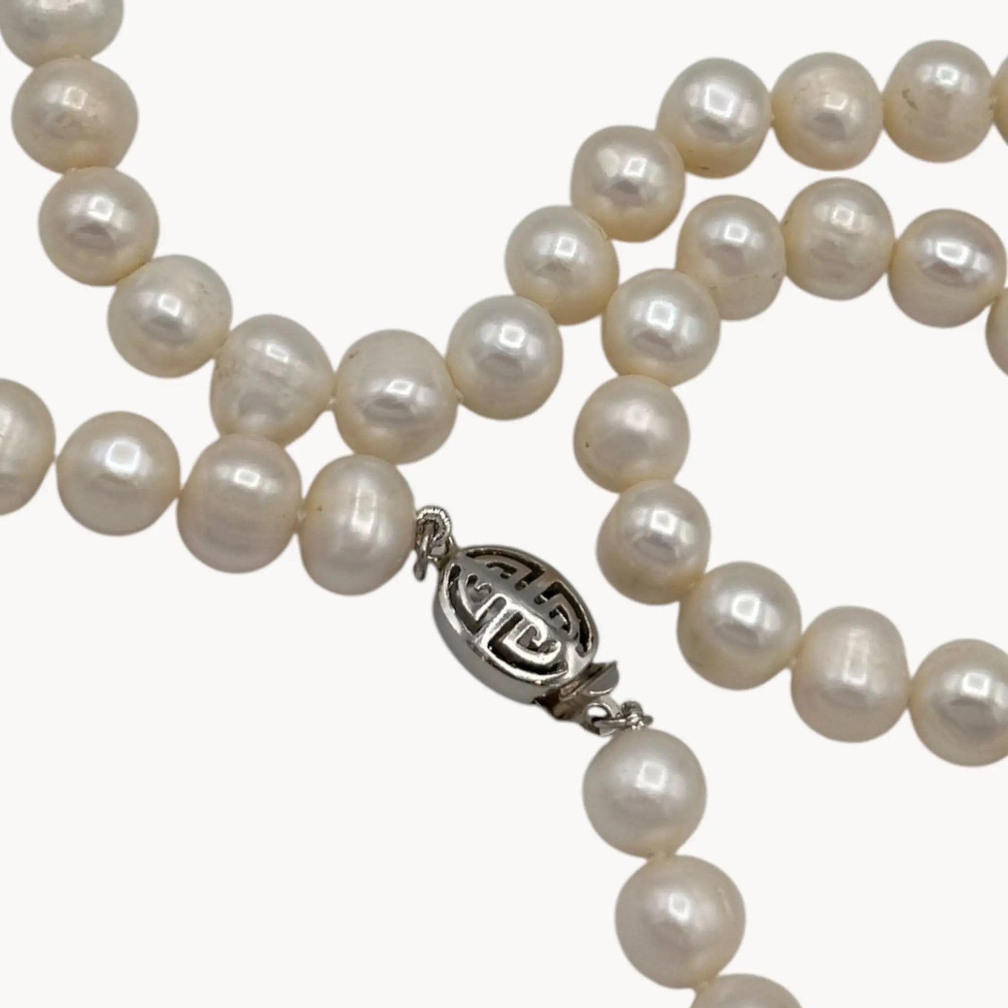 Pearl necklace with a silver clasp on a white background