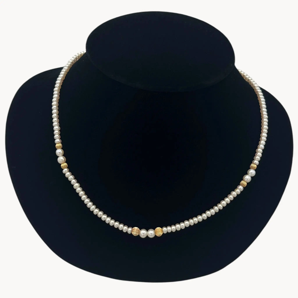Front view of Classic pearl and 14K gold bead strand necklace, vintage fine jewelry on black bust.
