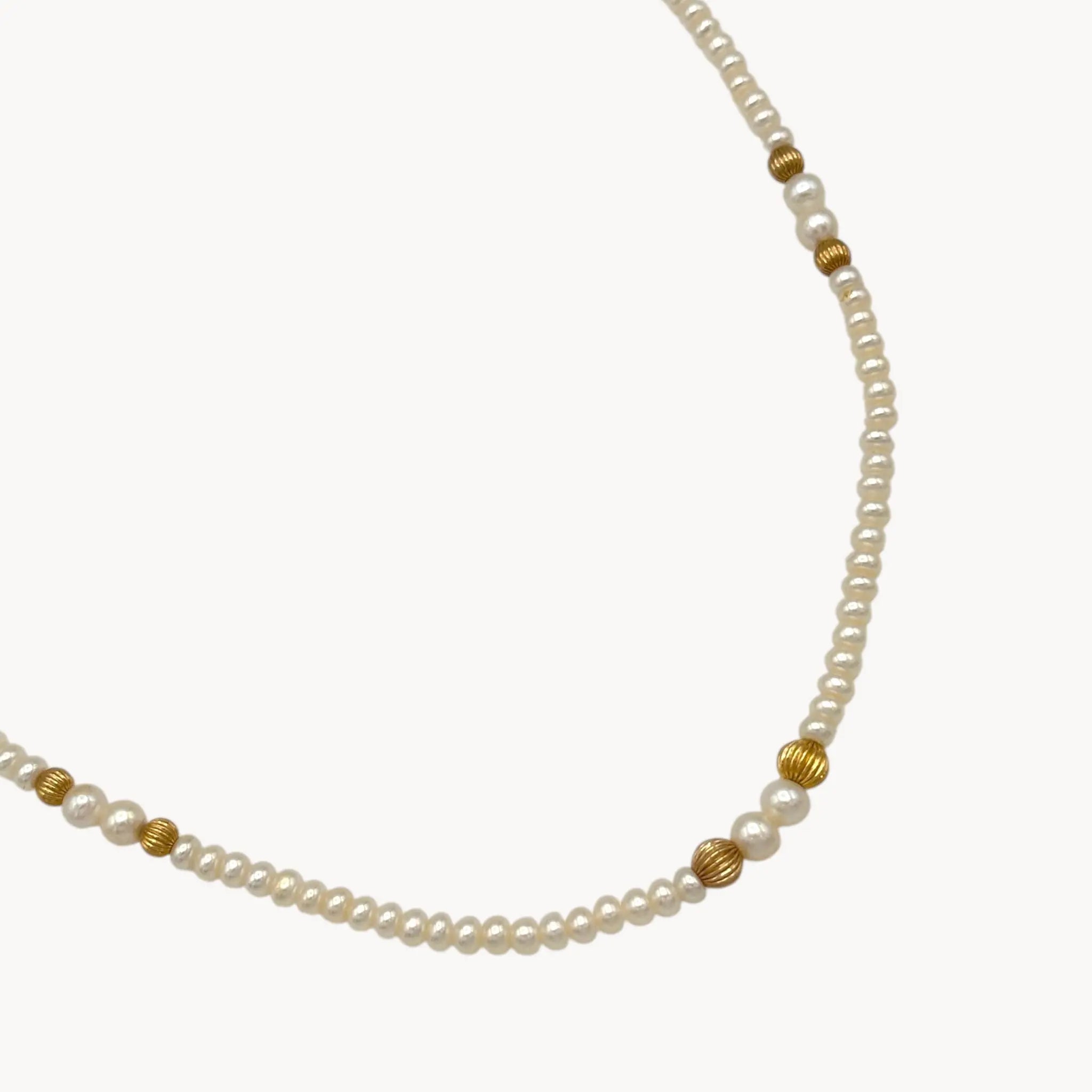 Close up view of gold beads of Classic pearl and 14K gold bead strand necklace, vintage fine jewelry on white background.