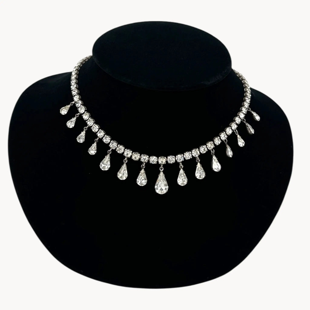 Close up view of Coro sterling silver Art Deco necklace with teardrop rhinestone pendant.