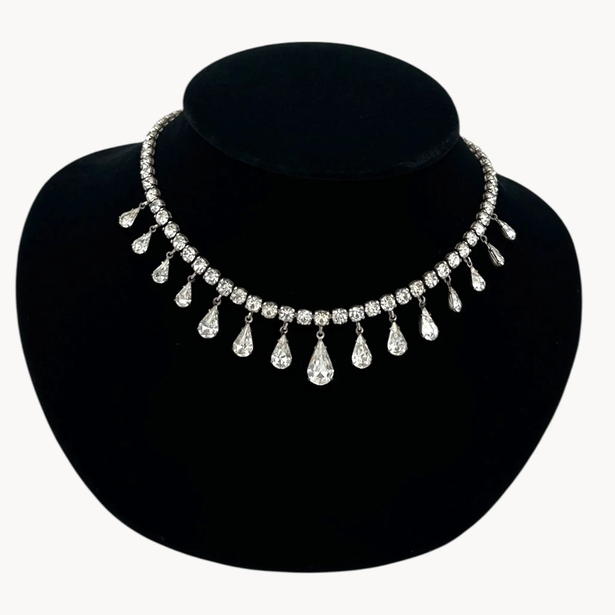 Close up view of Coro sterling silver Art Deco necklace with teardrop rhinestone pendant.