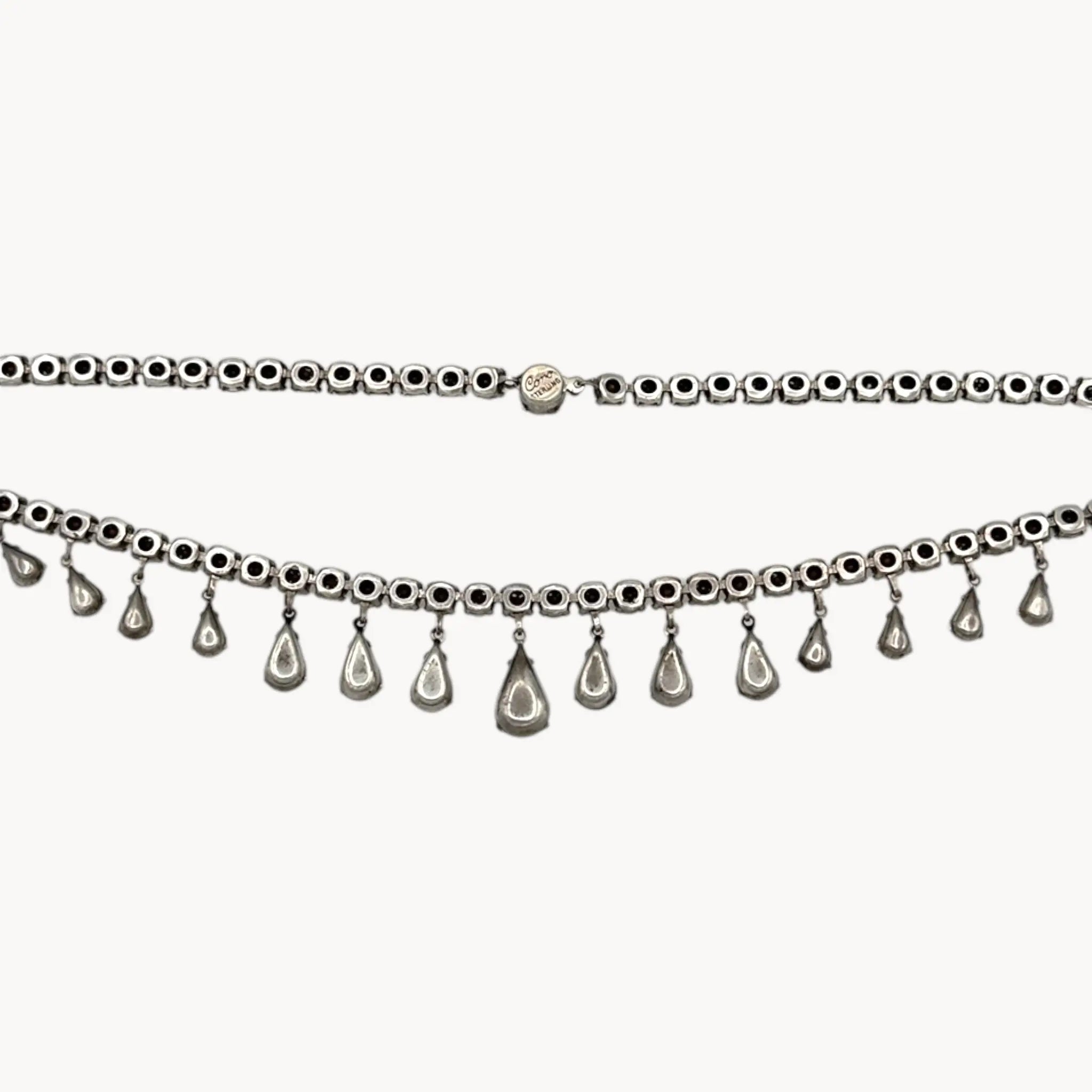 Back view of Coro sterling silver Art Deco necklace with teardrop rhinestone pendant on white background.