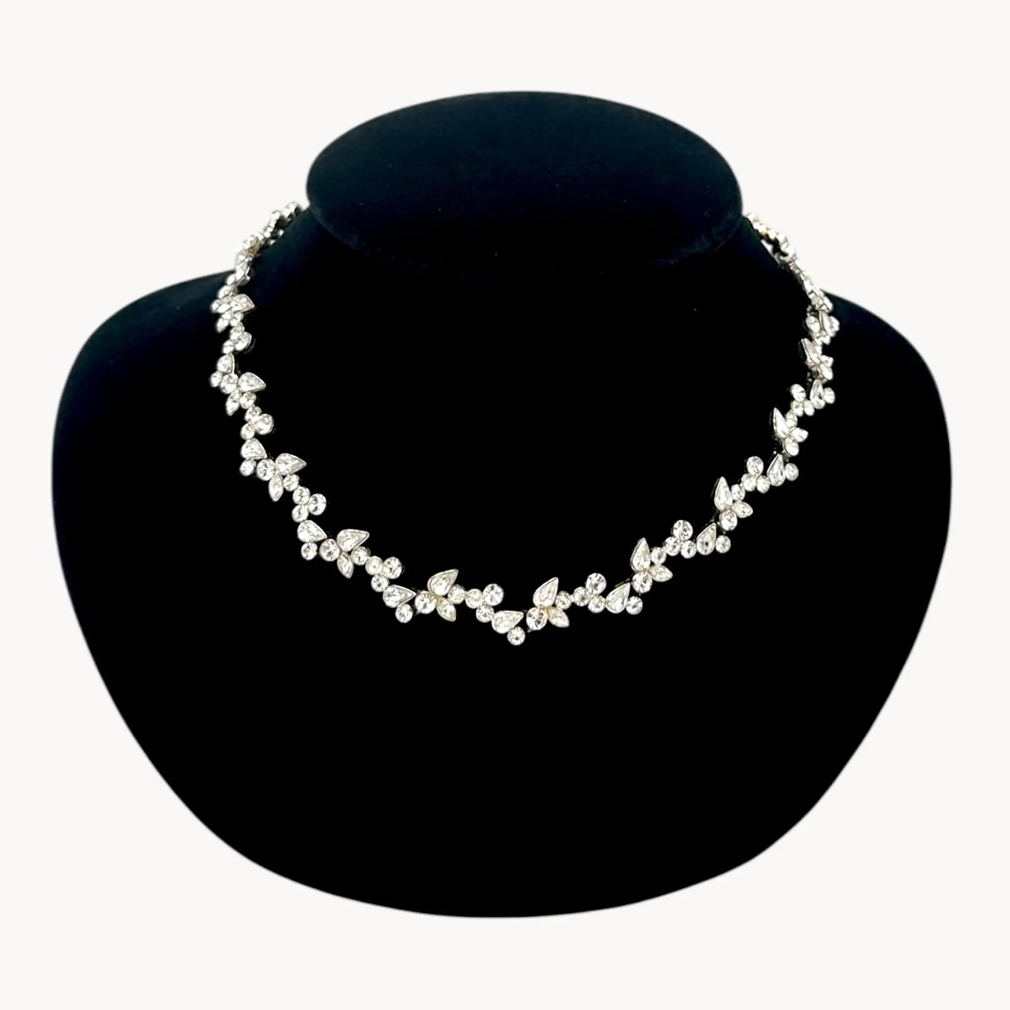 Close up view of Givenchy silver-tone floral crystal rhinestone necklace, vintage bridal jewelry on black bust.