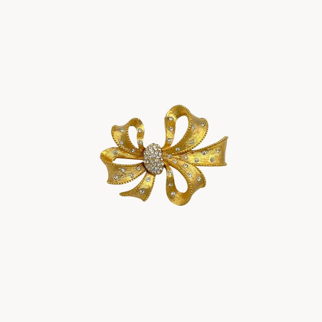 Close up view of Vintage gold rhinestone bow brooch with ribbon design