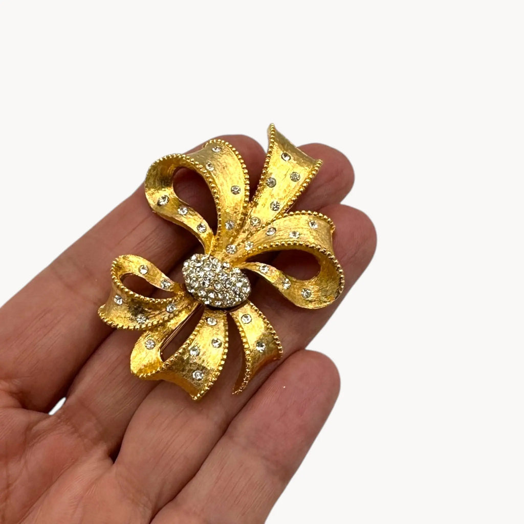 Size view of Vintage gold rhinestone bow brooch with ribbon design