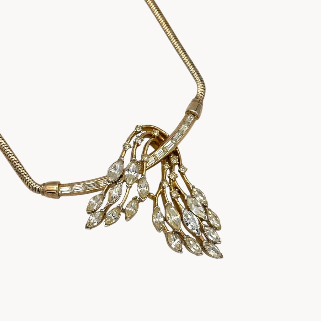 Close up view of pendant of 1950s Trifari rhinestone necklace with marquise spray design on snake chain, vintage mid-century bridal jewelry.
