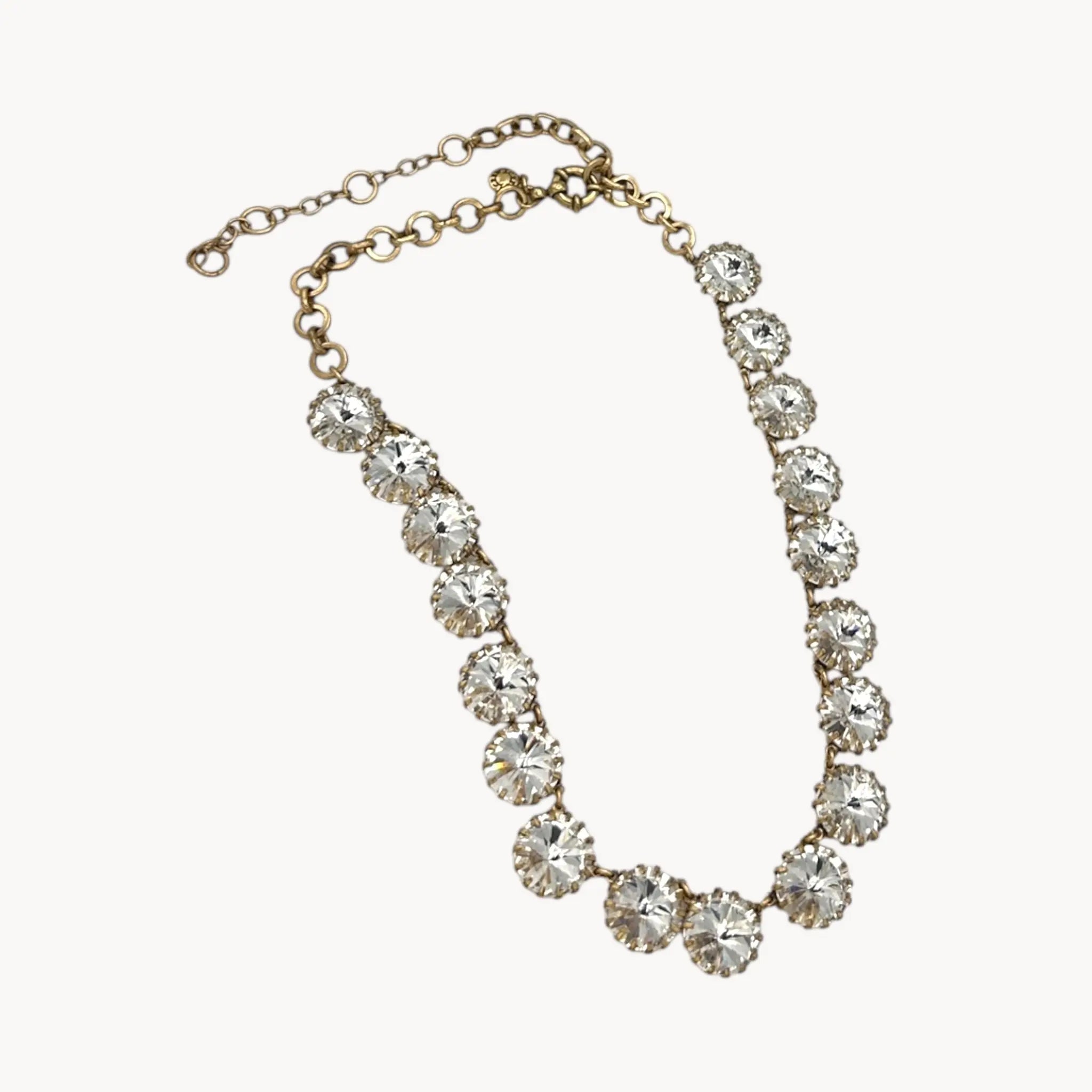 Close up view of J. Crew Venus Flytrap necklace with large clear round rhinestones on white background.