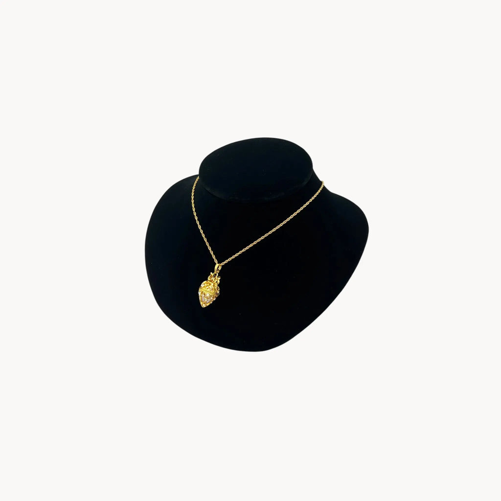 Side view of Joan Rivers gold egg locket necklace on long chain